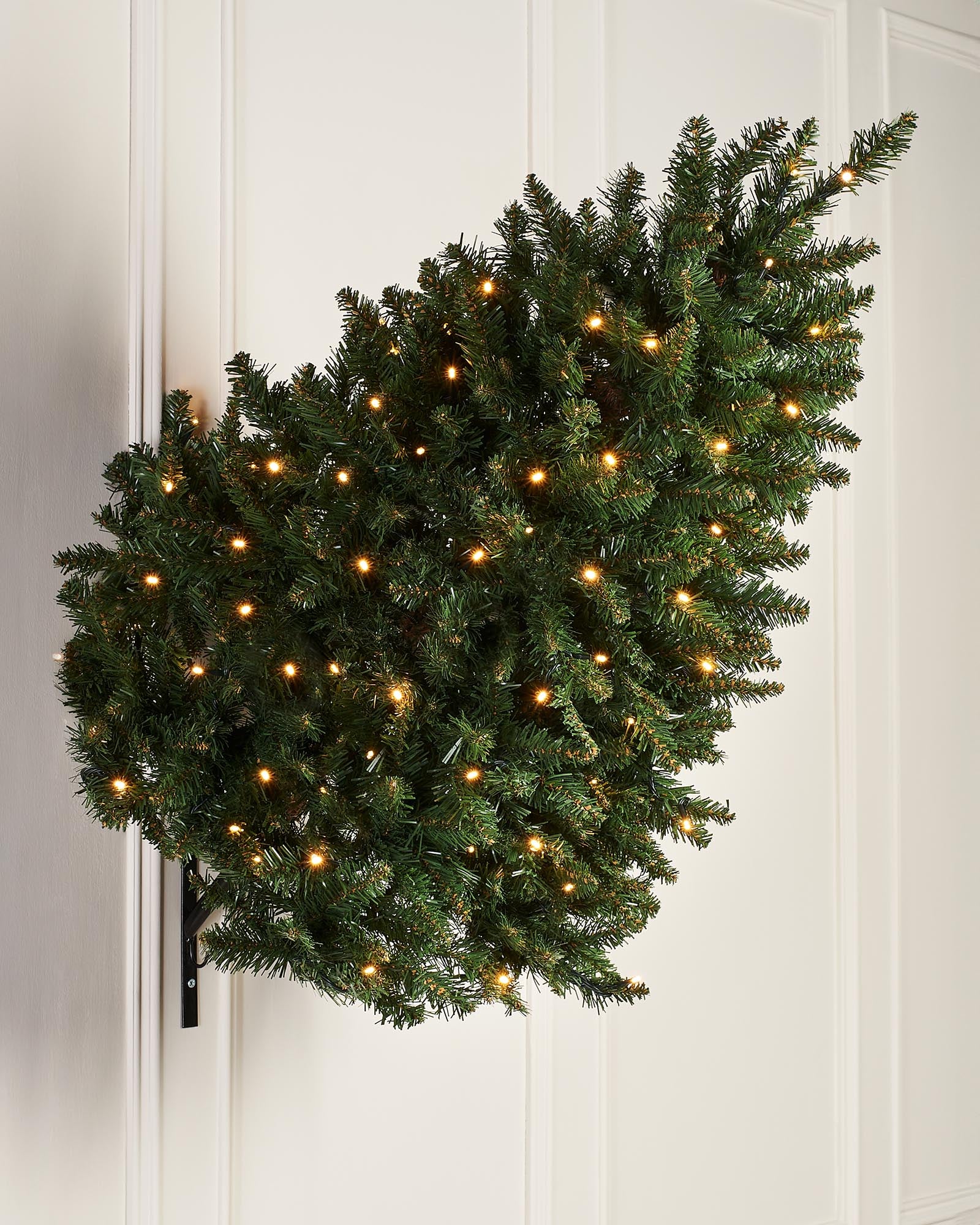A pre-lit green wall-mounted Christmas tree with 400 bullet tips and 100 warm white LED lights, featuring a compact 3 ft height and 55 cm diameter. The tree is illuminated with multi-functional lighting settings and designed to save space while adding festive warmth.