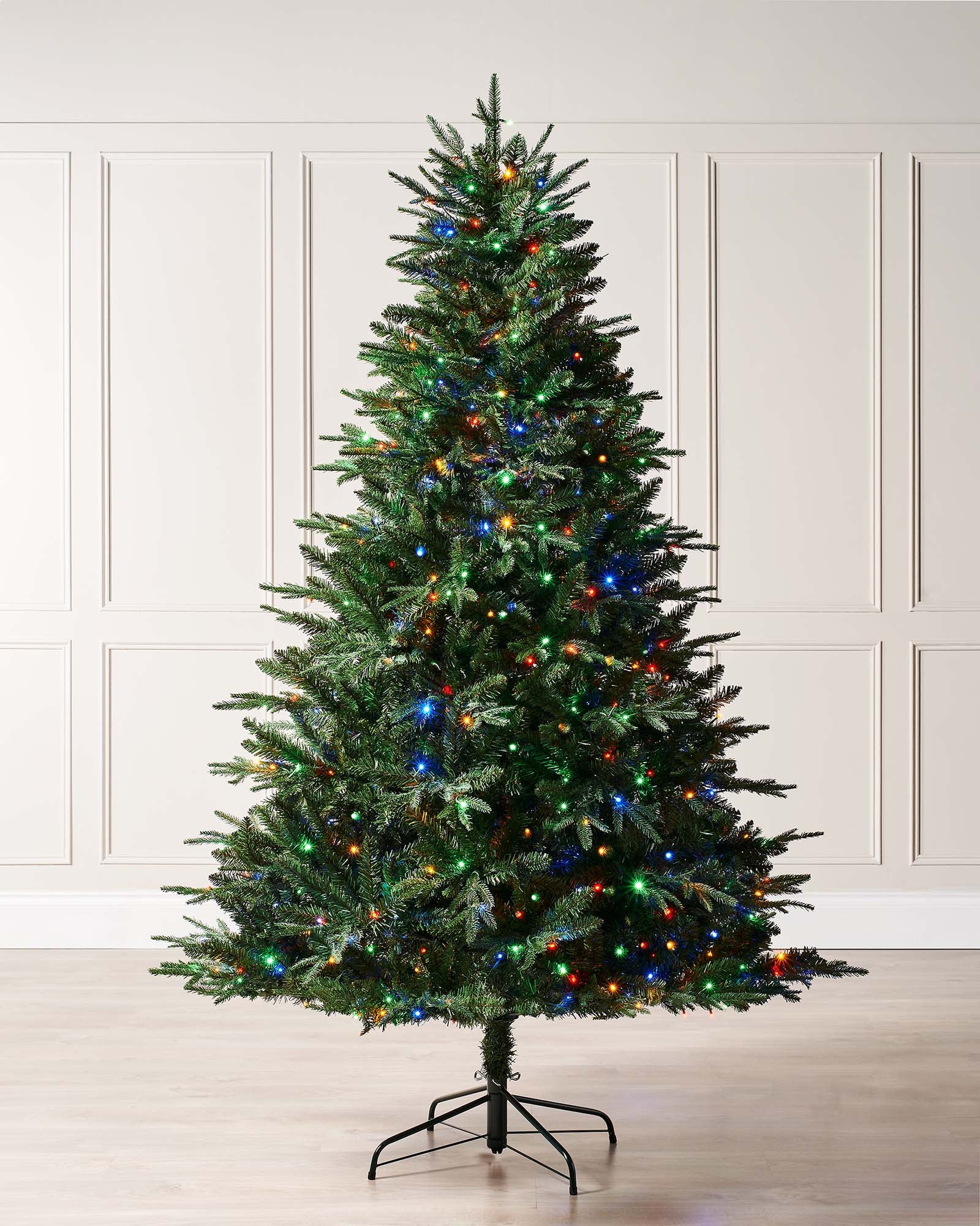 A pre-lit Grand Windsor fir Christmas tree with a full silhouette, featuring mixed PE and PVC tips and dual-function LEDs that switch between warm white and multicolour. Displayed indoors against a plain background.
