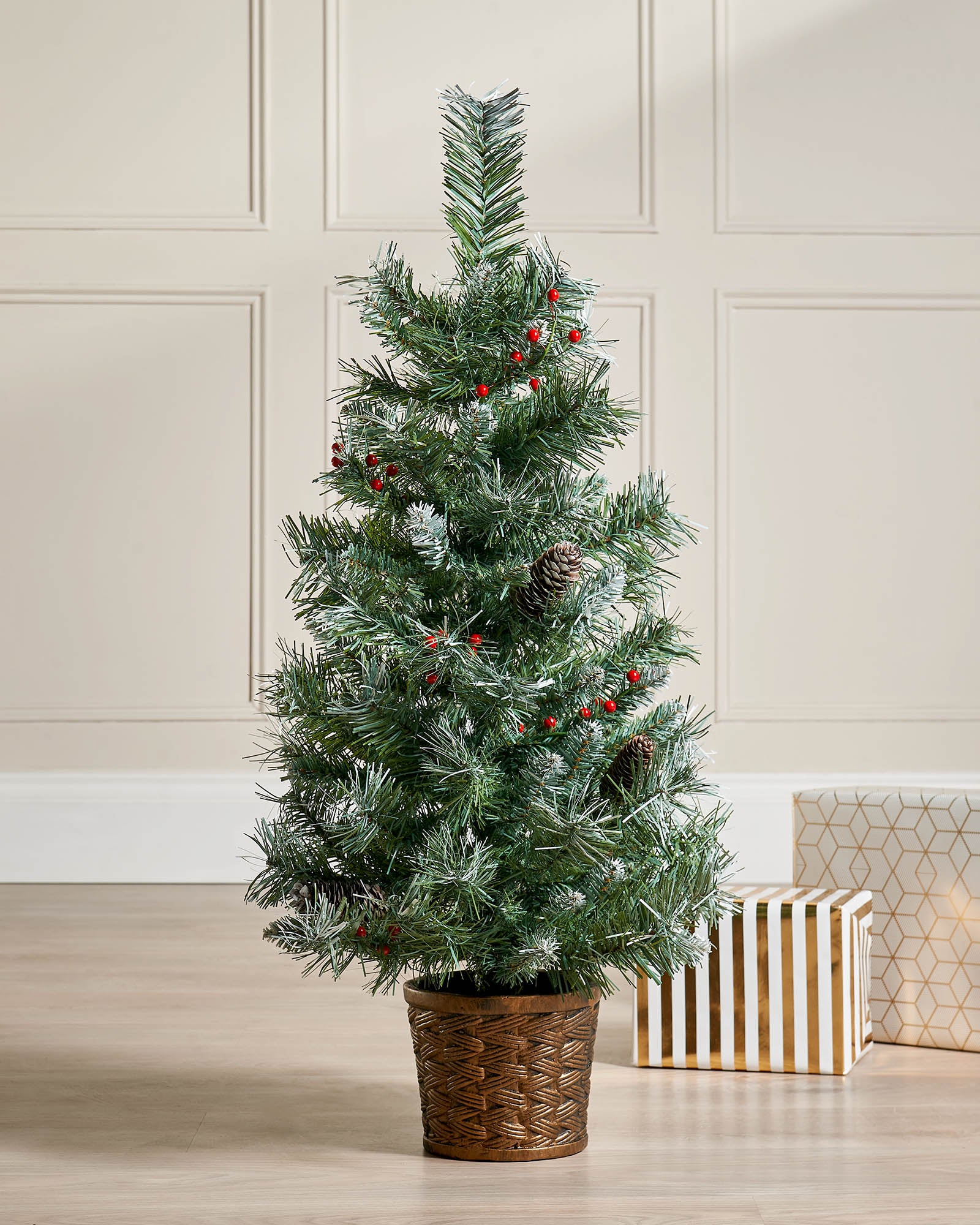 A 3-foot tall potted Scandinavian Blue Spruce Christmas tree with 200 PVC tips, decorated with red berries and pinecones. Set in a woven basket, the tree features lifelike foliage with soft blue-green hues, capturing a rustic, Nordic-inspired festive look.