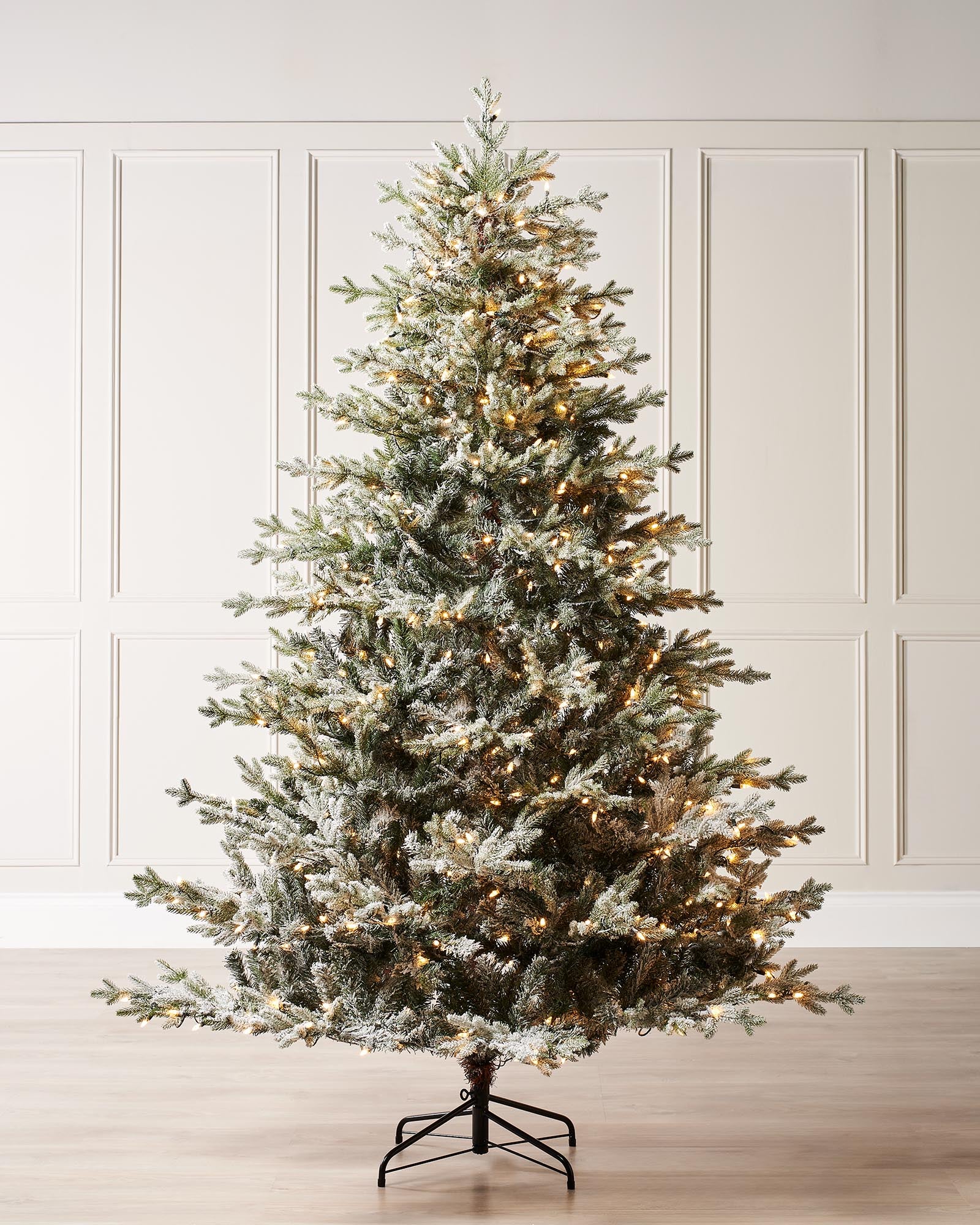 Pre-lit snow flocked Fraser Fir artificial Christmas tree with warm white LED lights, featuring mixed PE and PVC branches, full silhouette, and 8-function lighting, displayed against a neutral background.
