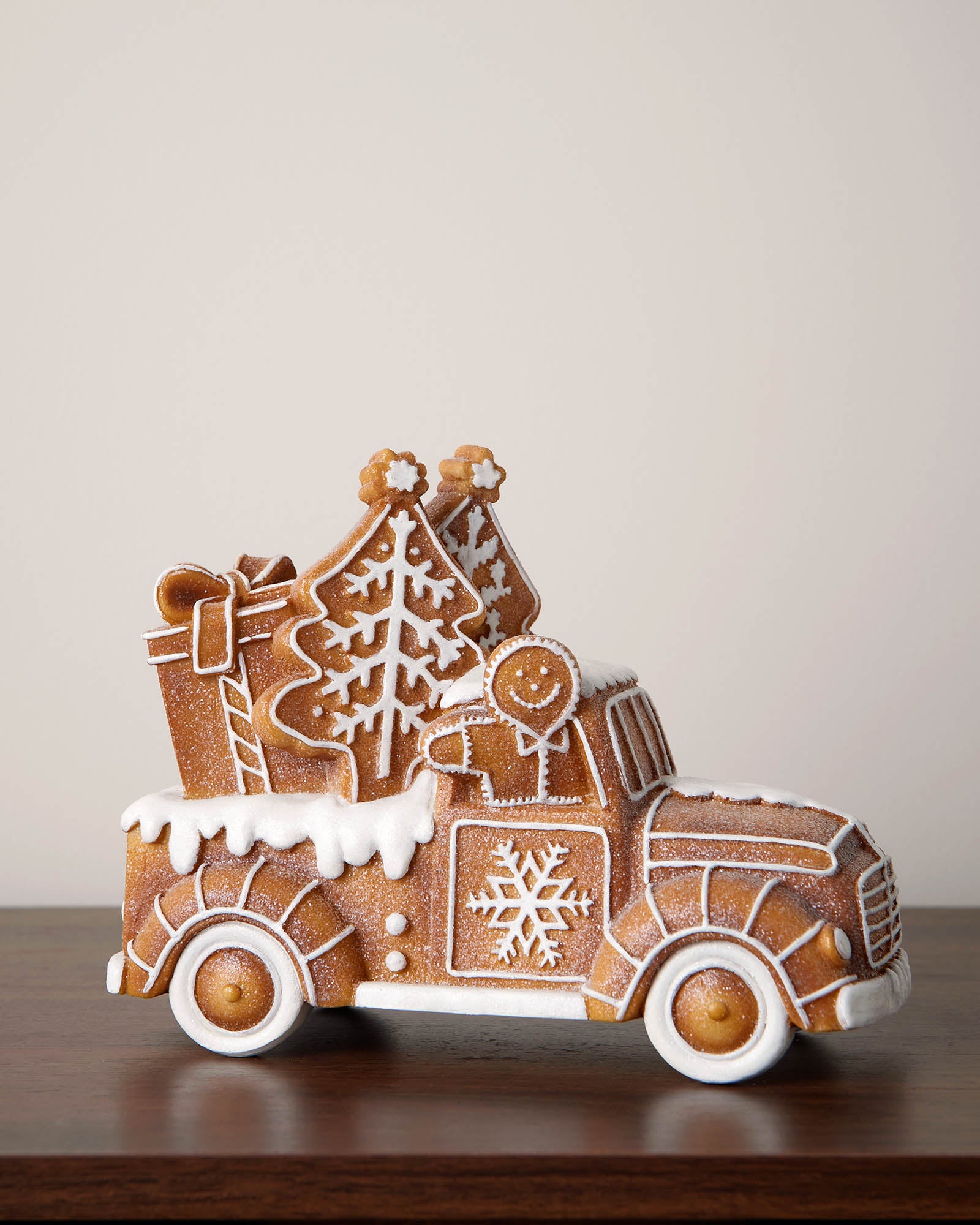 Gingerbread truck with tree and presents on a reflective surface