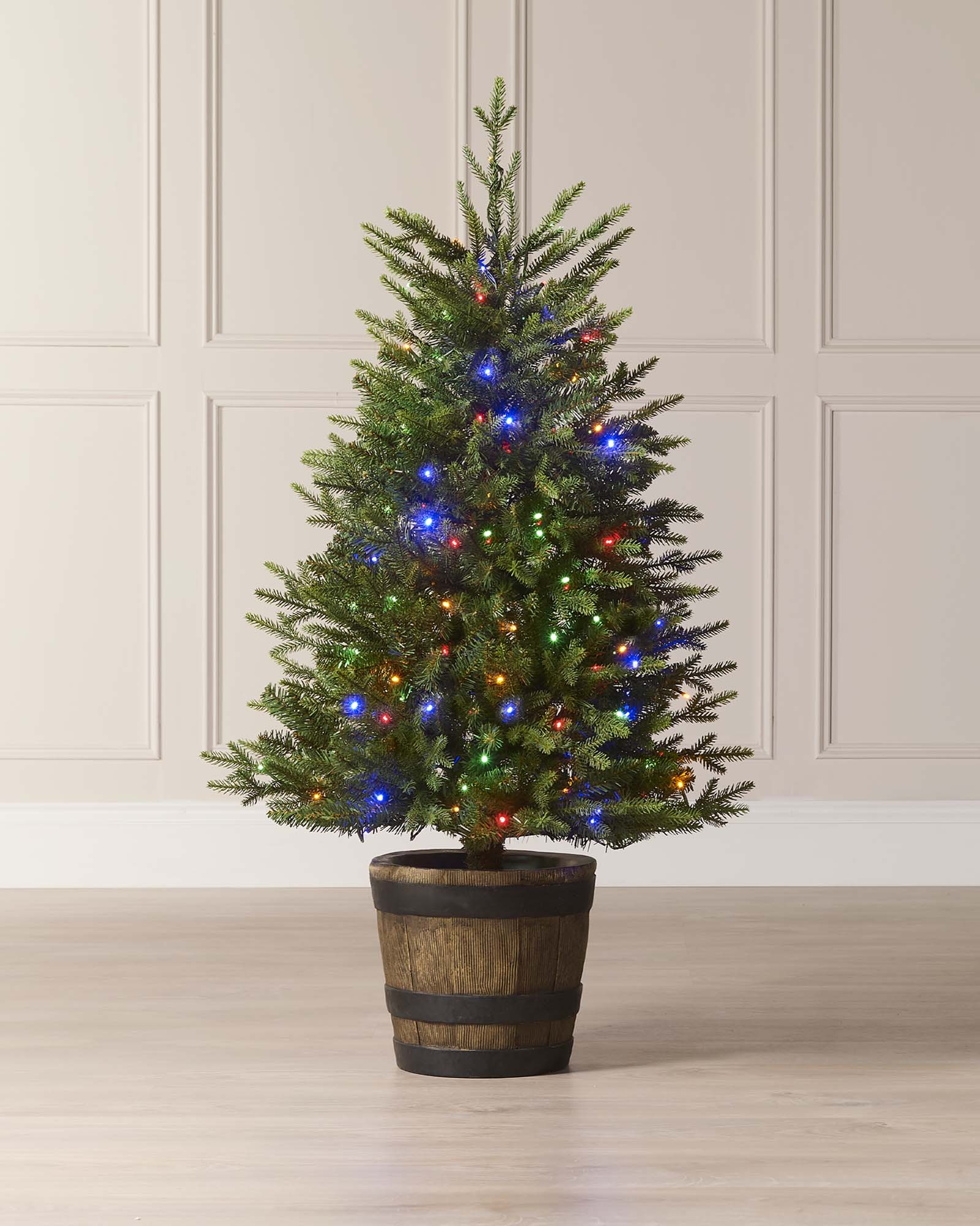 A 4 ft pre-lit potted pine Christmas tree with dense green foliage, dual warm white and multicolour LED lights, placed in a decorative pot indoors or outdoors.