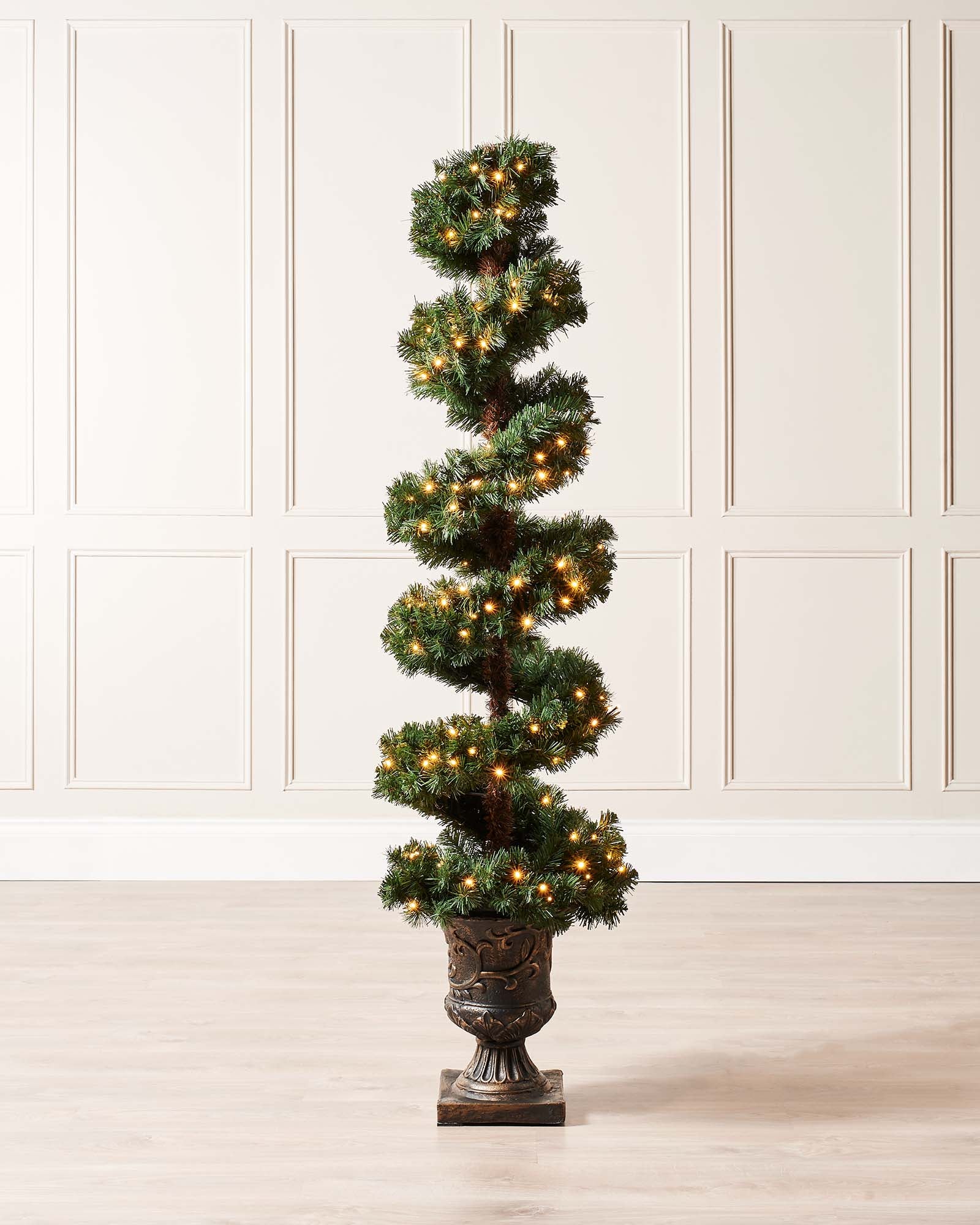6-foot pre-lit spiral potted Christmas tree with a slender 41 cm diameter, featuring 400 PVC tips shaped in a modern spiral design. Decorated with warm white LED lights and red berries, displayed indoors in a stylish pot.