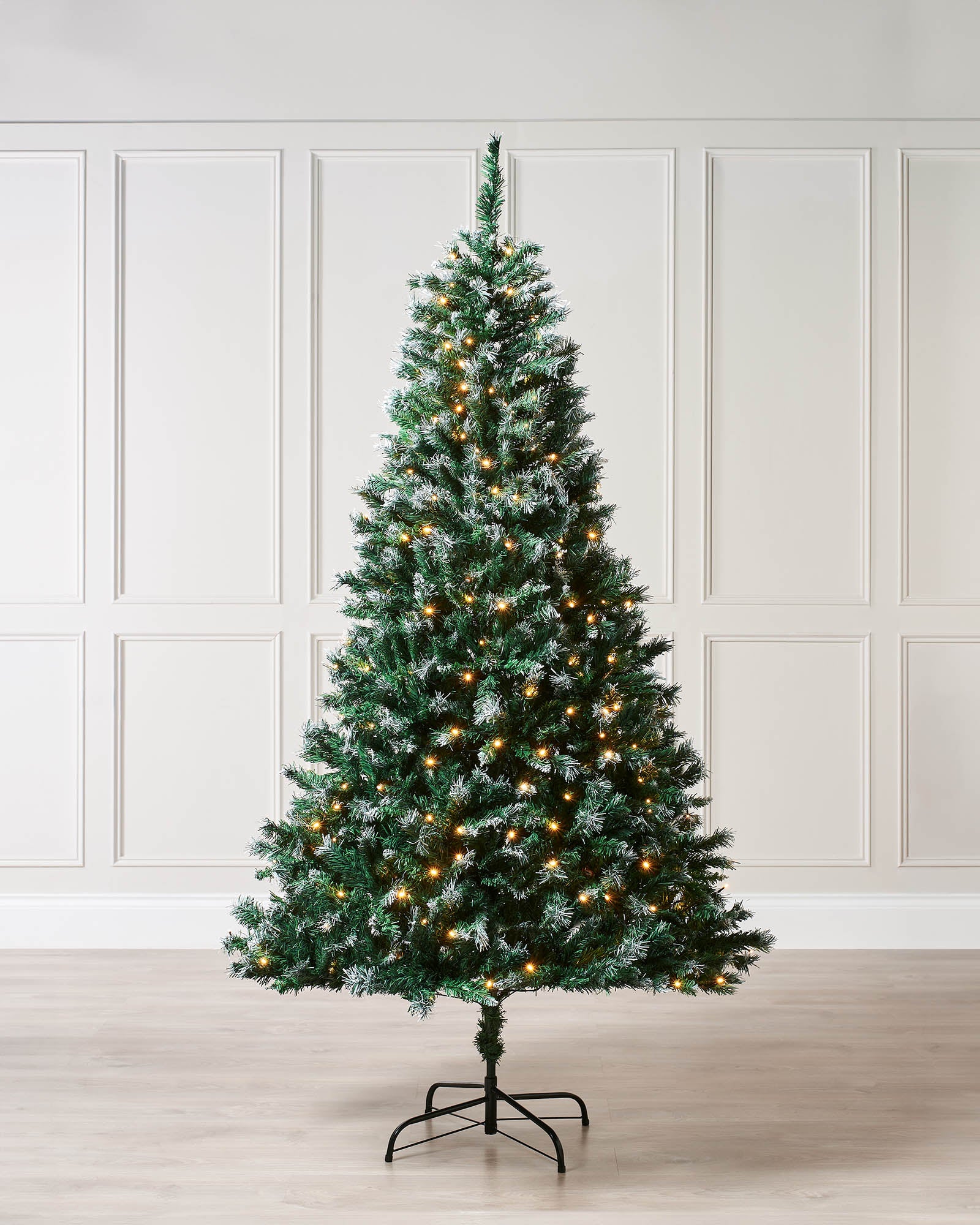6ft pre-lit snow-tipped mixed pine Christmas tree with V-cut and bullet tips, warm white LED lights, and a balanced silhouette, displayed on a metal stand against a white background.