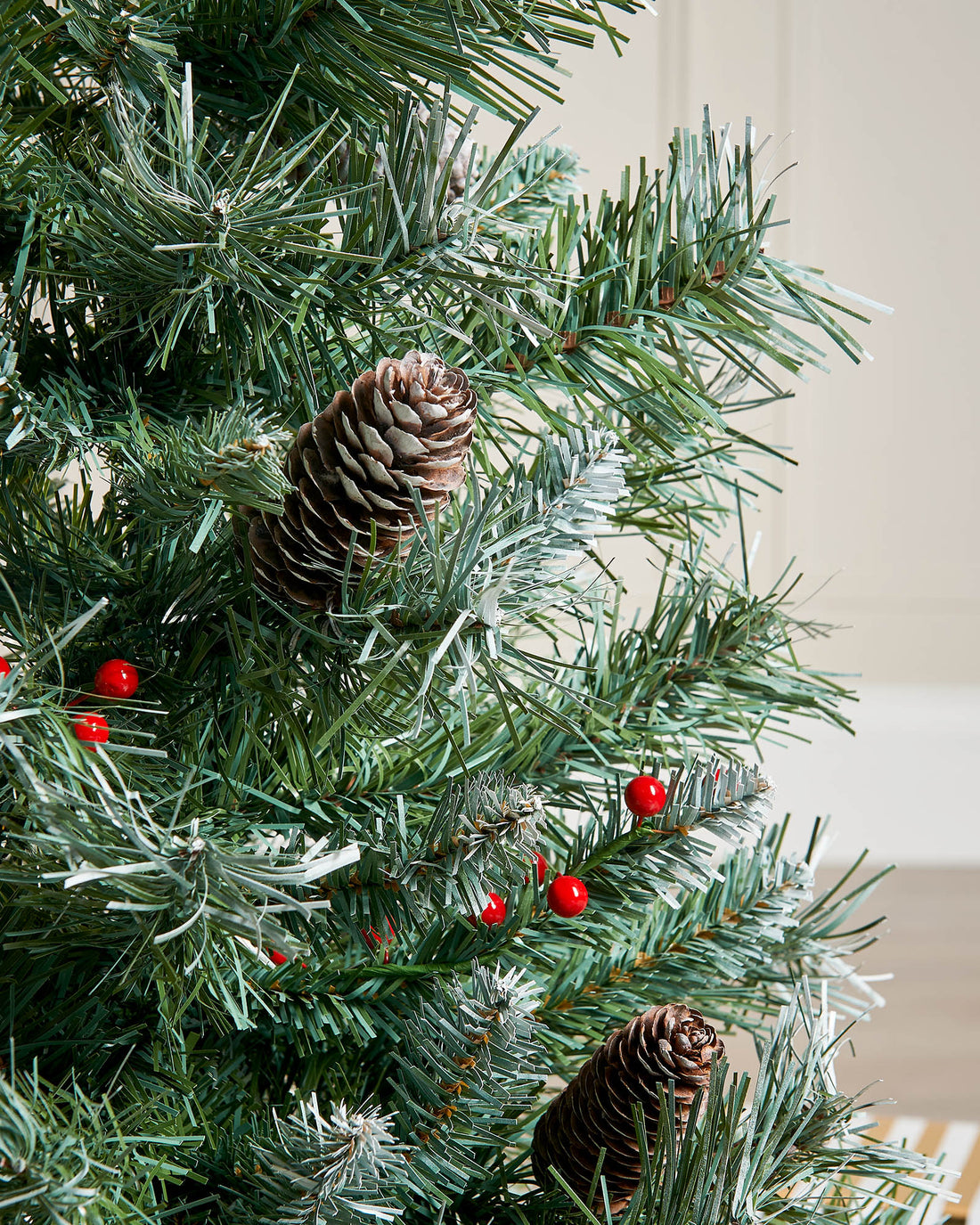 A 3-foot tall potted Scandinavian Blue Spruce Christmas tree with 200 PVC tips, decorated with red berries and pinecones. Set in a woven basket, the tree features lifelike foliage with soft blue-green hues, capturing a rustic, Nordic-inspired festive look.