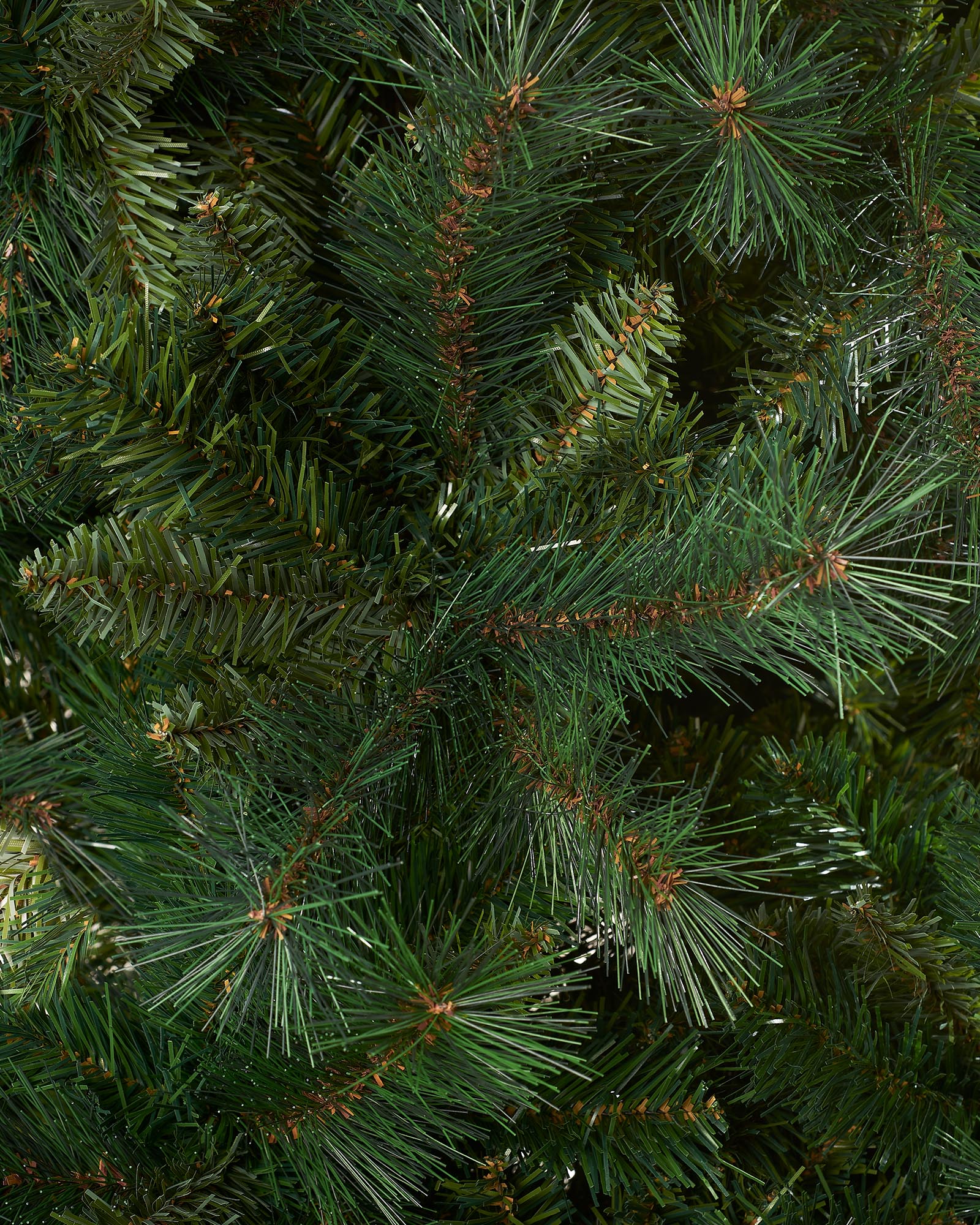 Full-bodied Victorian Pine artificial Christmas tree with dense green needles and a sturdy metal stand, showcasing a realistic and classic design that brings timeless elegance and festive charm to any indoor space.