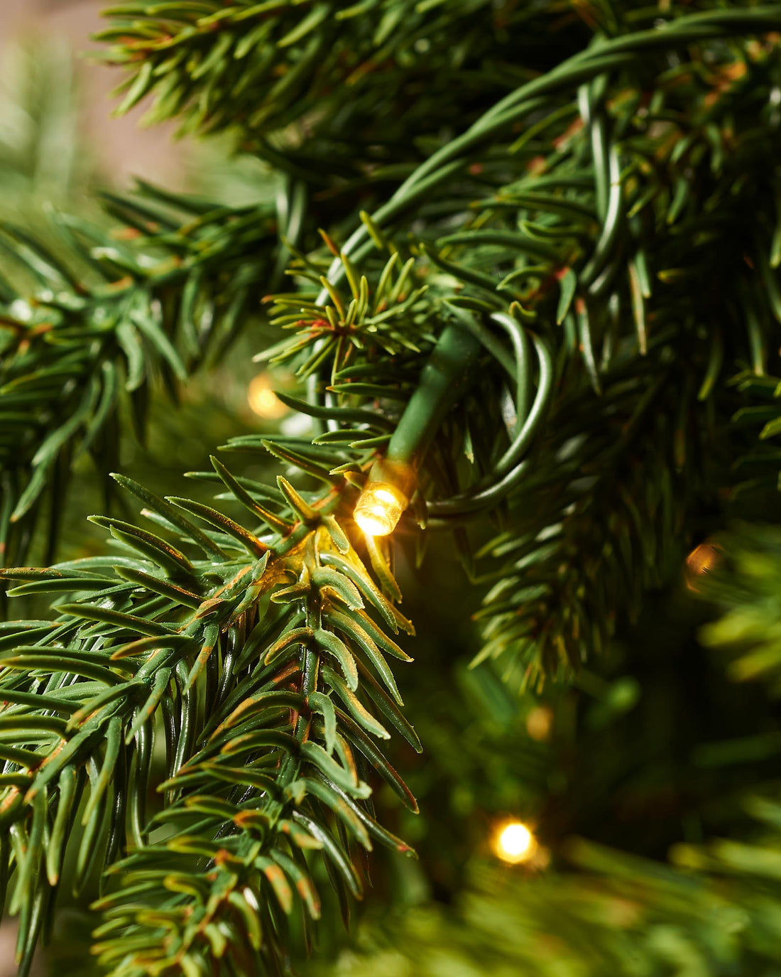 Pre-lit Himalayan fir Christmas tree with realistic green branches and warm white LED lights, displayed against a plain background. Designed for easy assembly with mixed realistic tips and built-in multi-setting lighting controller.