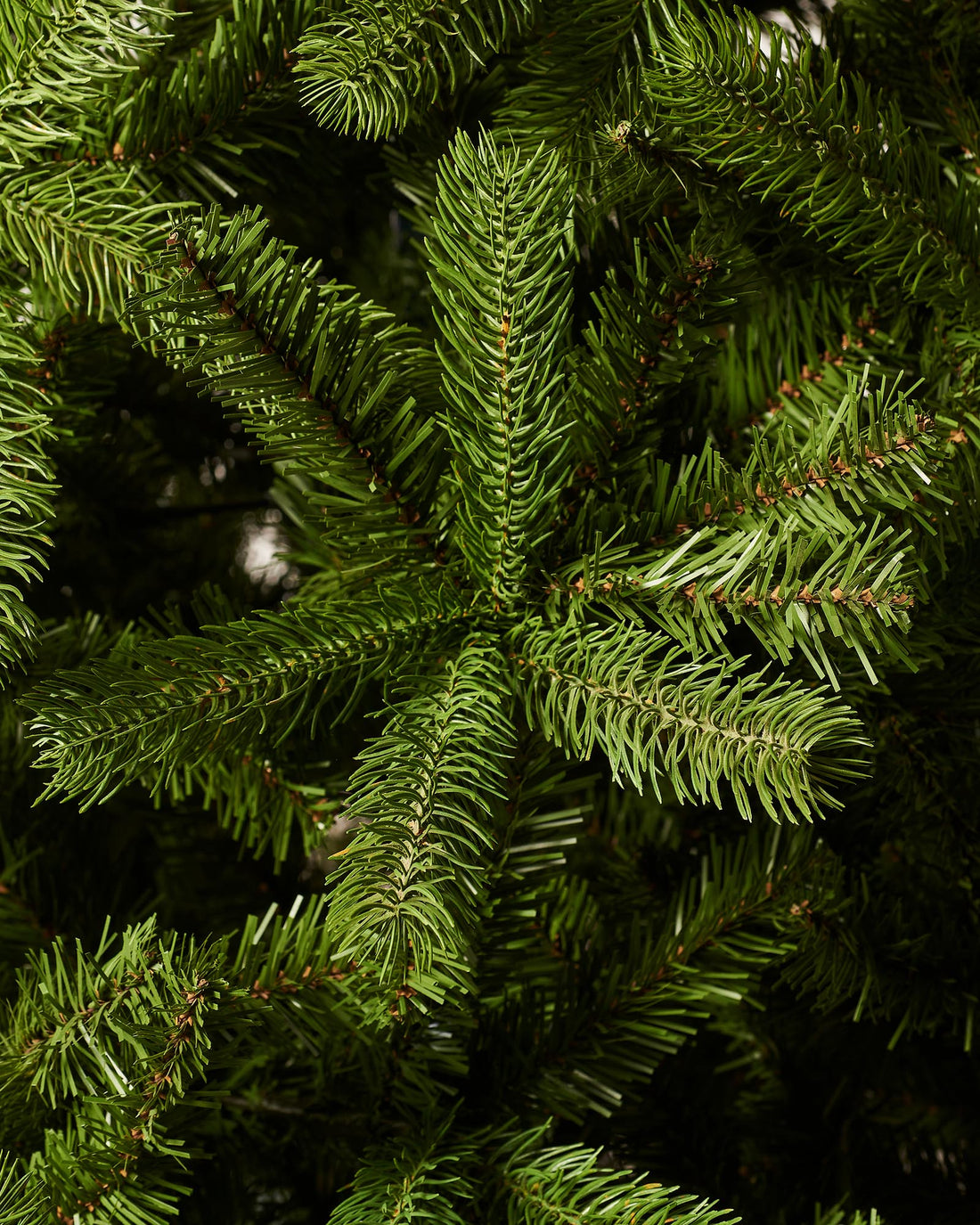 A 8-foot tall mixed pine artificial Christmas tree with a foldable black metal base.