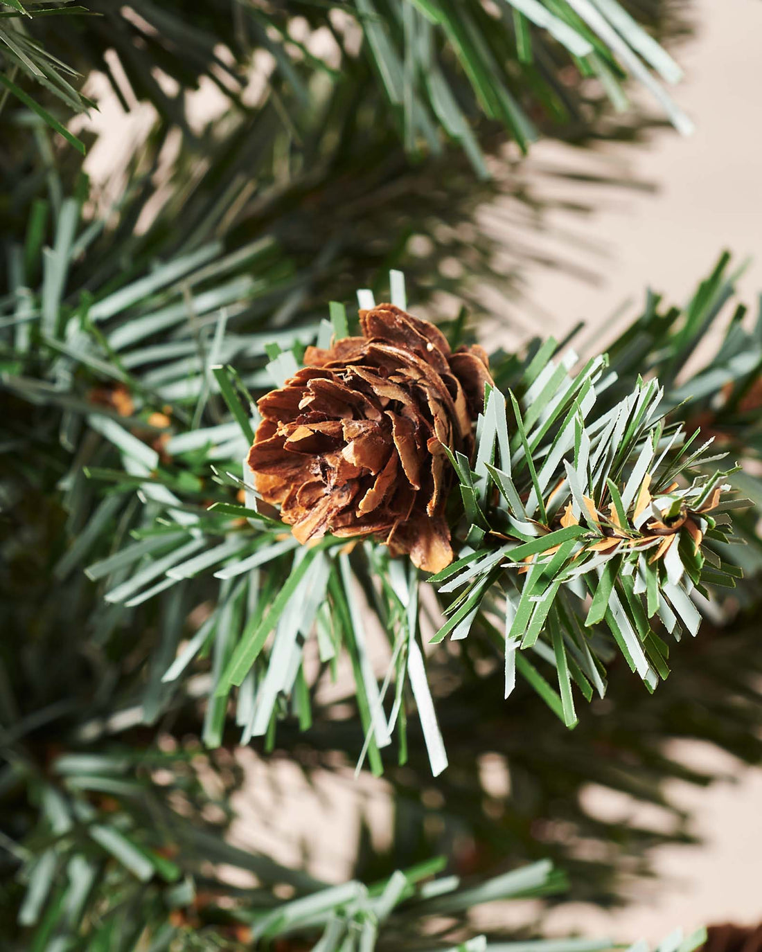 3-foot tall potted Crawford Blue Pine Christmas tree with 102 PVC tips, decorated with rustic pinecones, displayed indoors in a decorative pot