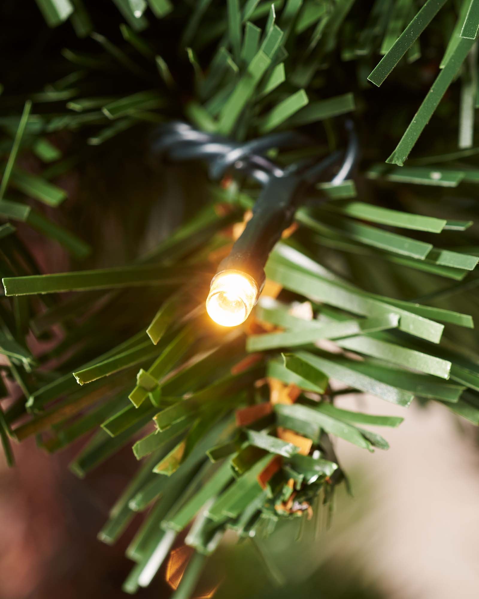 6-foot pre-lit spiral potted Christmas tree with a slender 41 cm diameter, featuring 400 PVC tips shaped in a modern spiral design. Decorated with warm white LED lights and red berries, displayed indoors in a stylish pot.