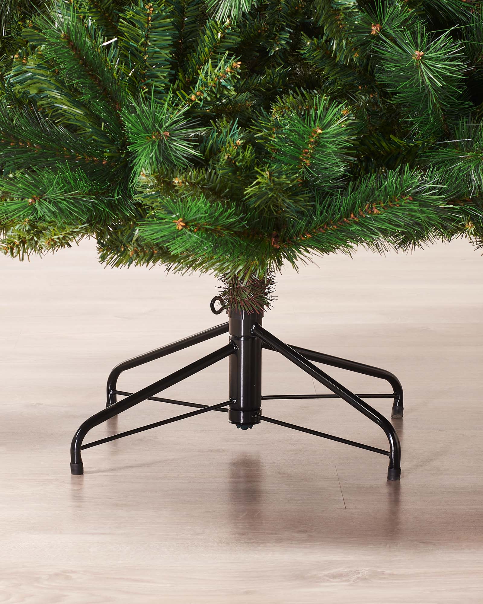 Full-bodied Victorian Pine artificial Christmas tree with dense green needles and a sturdy metal stand, showcasing a realistic and classic design that brings timeless elegance and festive charm to any indoor space.