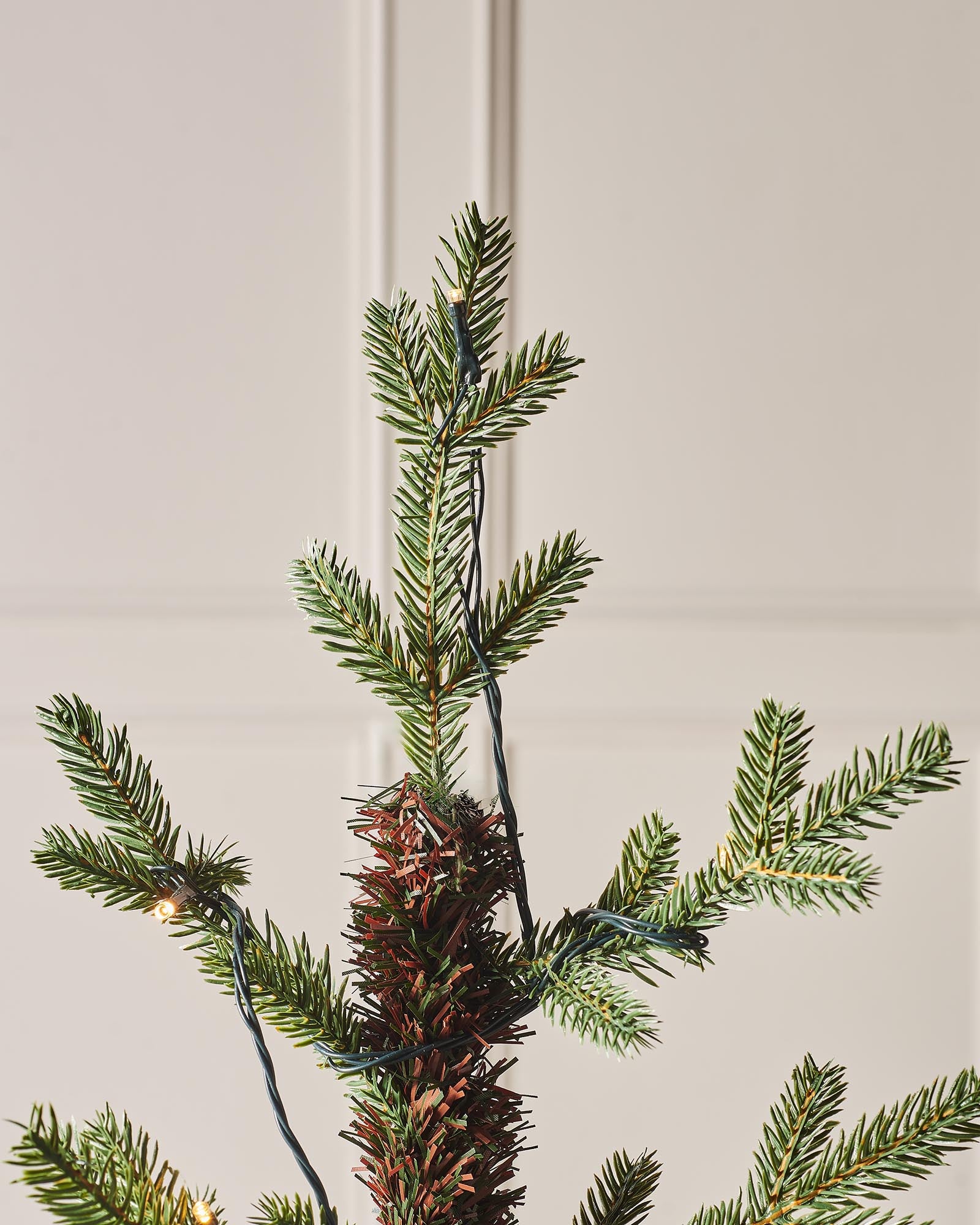 Pre-lit Norway Spruce potted Christmas tree with realistic green branches, warm white LED lights, and a rustic hessian-wrapped base.