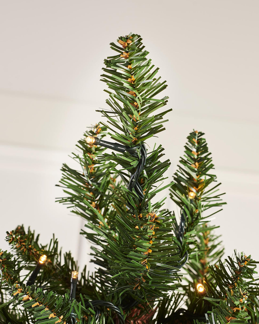 A pre-lit green wall-mounted Christmas tree with 400 bullet tips and 100 warm white LED lights, featuring a compact 3 ft height and 55 cm diameter. The tree is illuminated with multi-functional lighting settings and designed to save space while adding festive warmth.