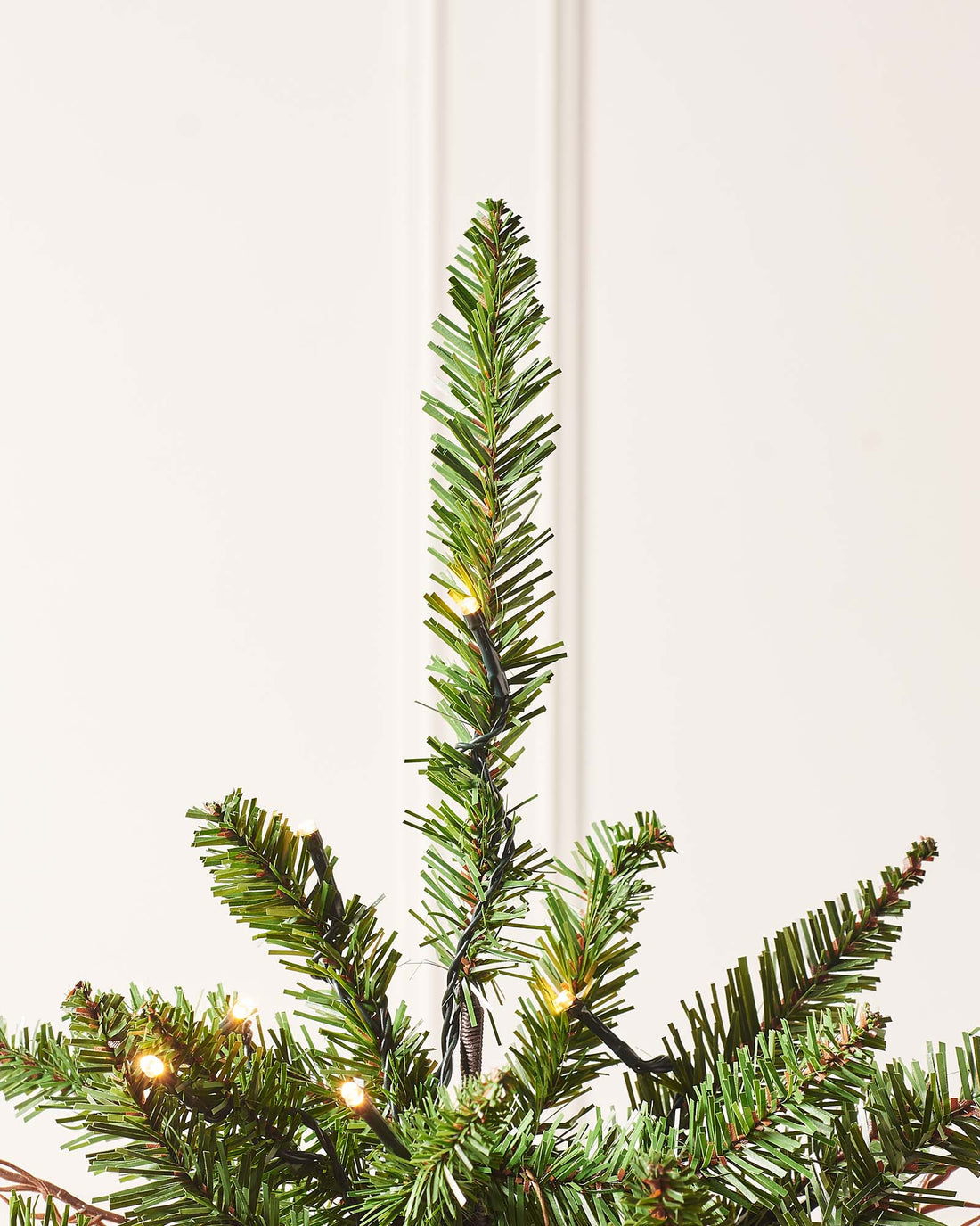 4.5-foot pre-lit potted Christmas tree with lush green mixed PE and PVC foliage, warm white LED lights, red berries, and natural brown pinecones, displayed indoors.