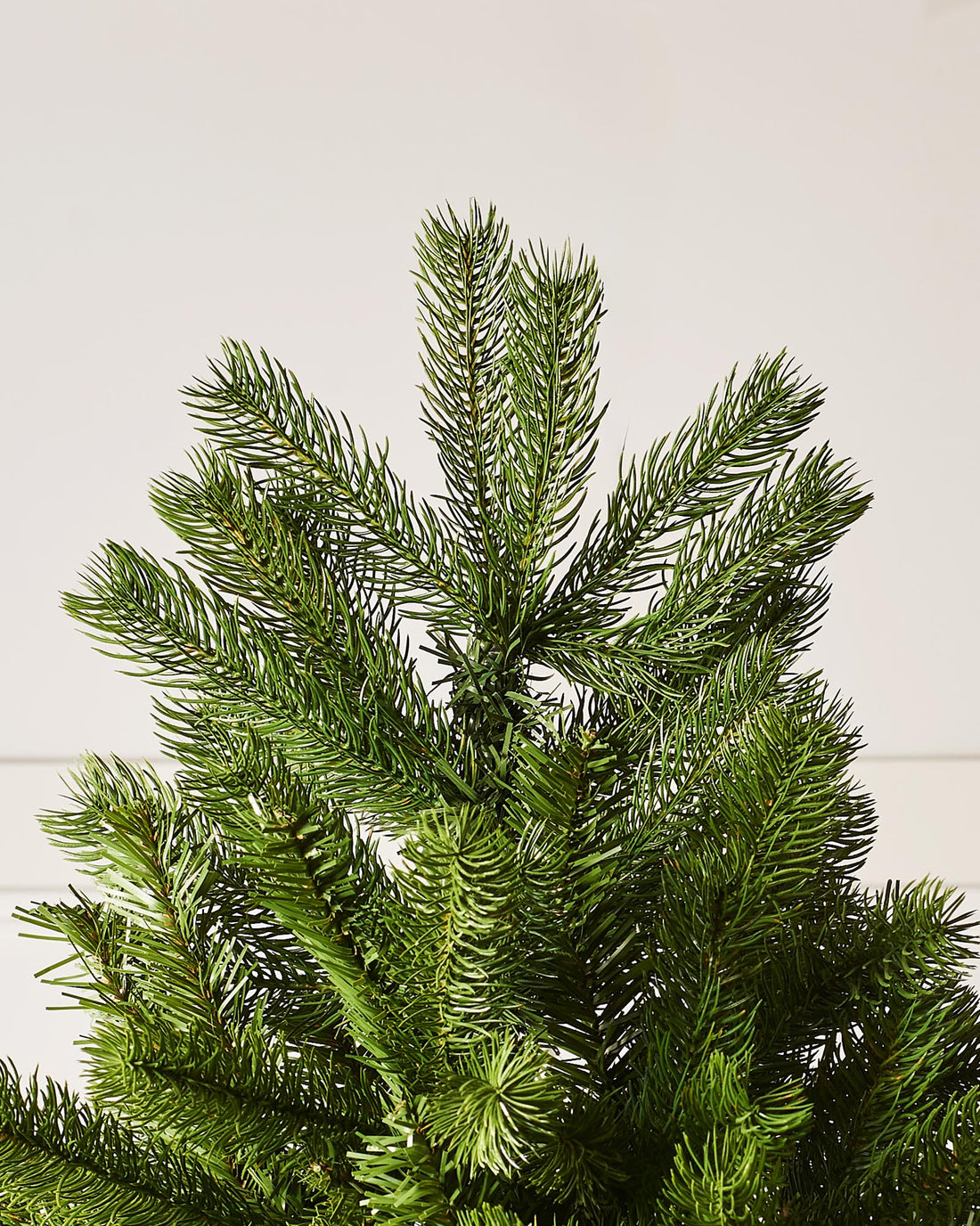 A 8-foot tall mixed pine artificial Christmas tree with a foldable black metal base.