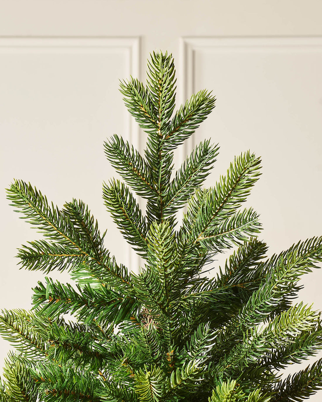 A realistic Himalayan Fir artificial Christmas tree with lush PE and PVC branches, featuring a natural fir-like appearance and a sturdy metal stand, ideal as a timeless, festive centrepiece for cosy or spacious indoor settings.