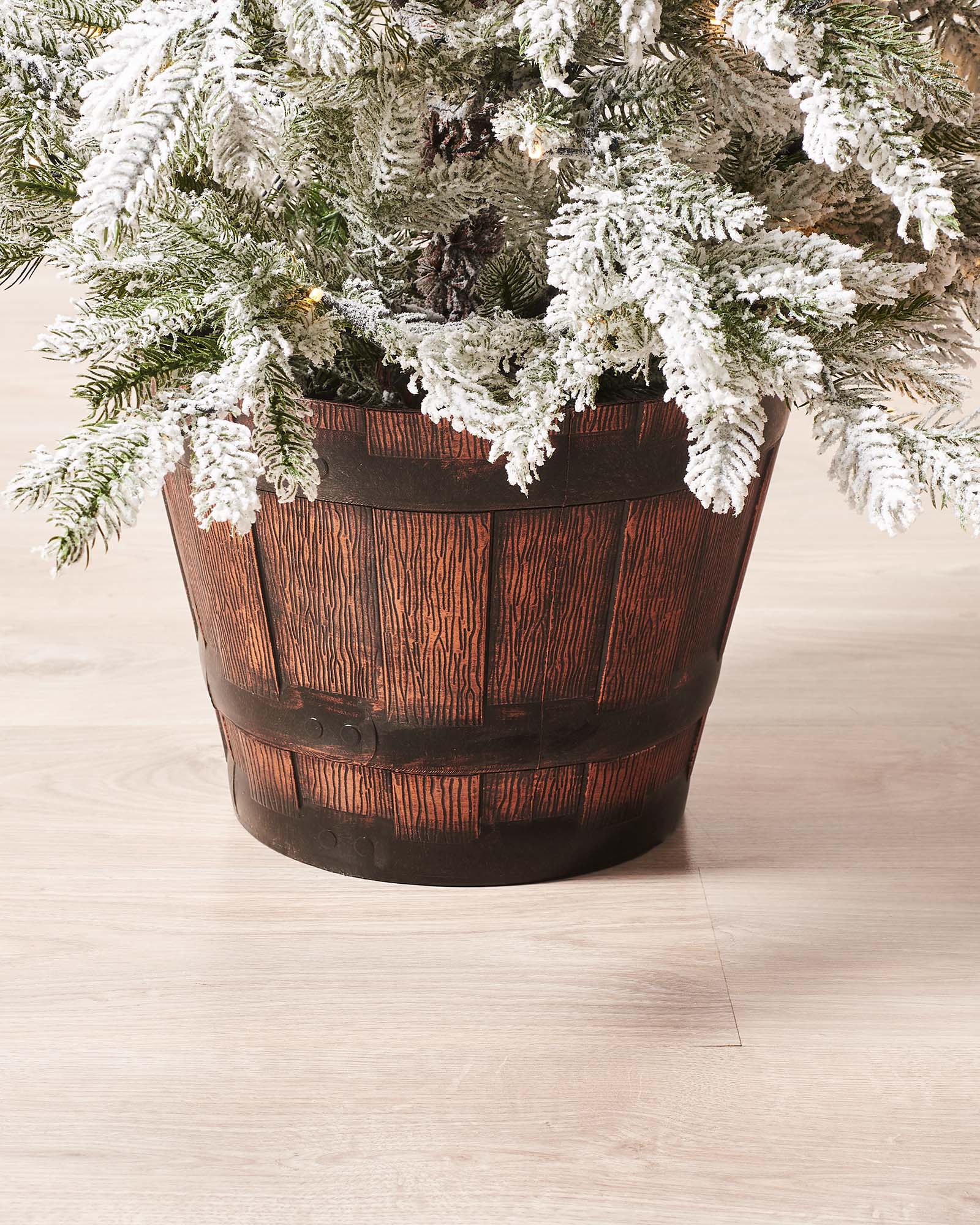 Pre-lit 4-foot snow flocked Christmas tree in a stylish pot, featuring dense mixed PE and PVC branches. Dual warm and ice white LED lights with 8 lighting modes illuminate the tree, which stands on a flexible 3-metre lead.
