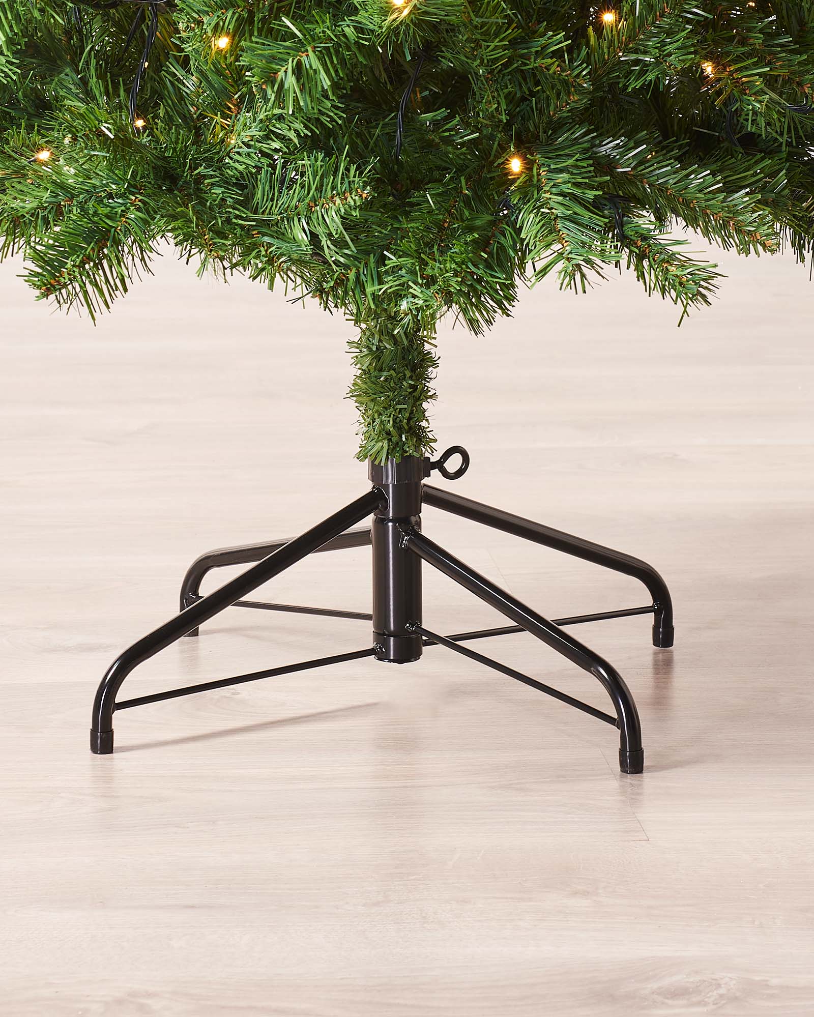 A 6 ft pre-lit slim Christmas tree featuring 508 lush PVC tips and 200 warm white LED lights, displayed indoors. The slender silhouette emits a cosy, inviting glow, ideal for adding festive charm to both compact and spacious settings.