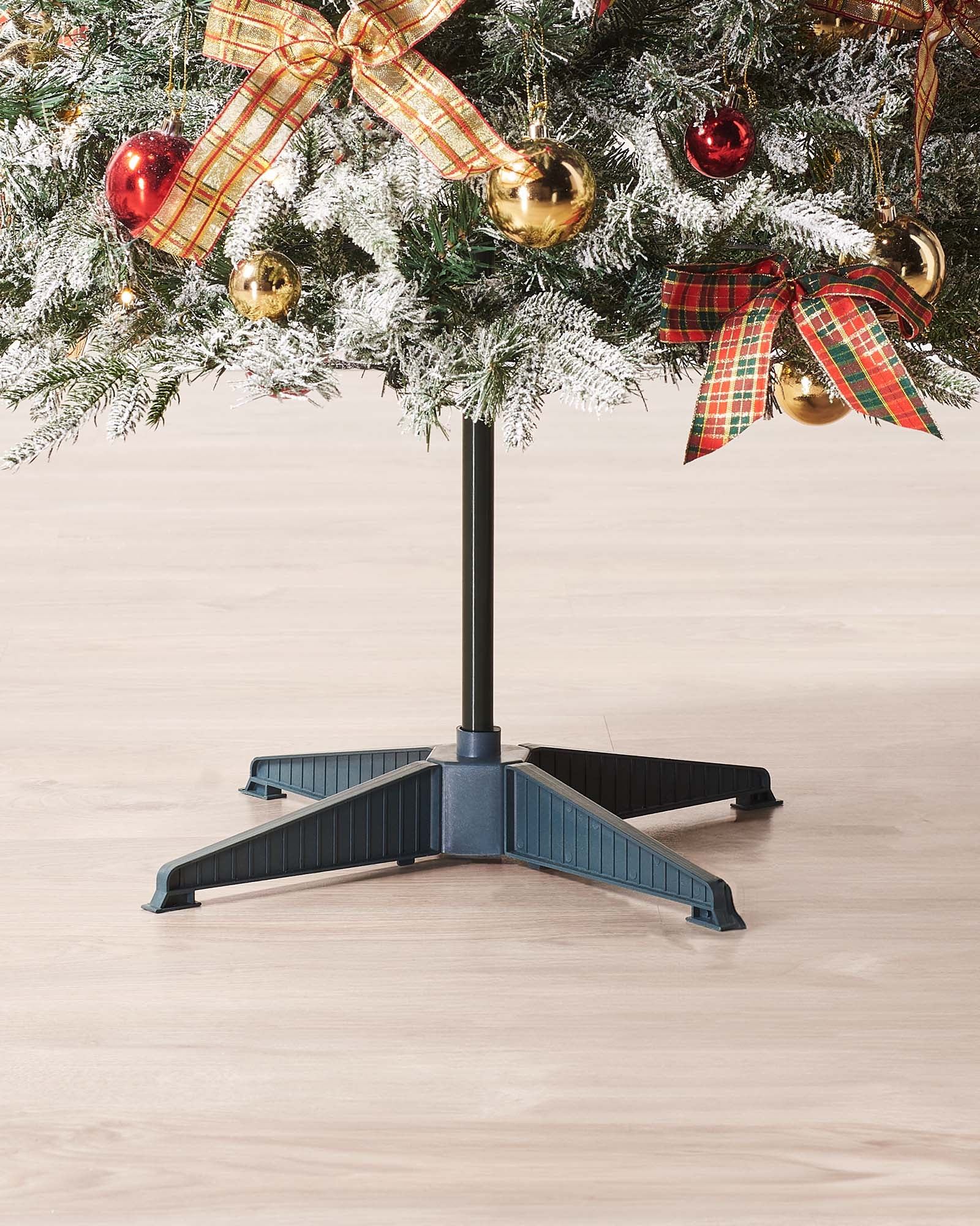 A 6-foot pre-lit pop-up artificial Christmas tree decorated with red and gold baubles and bows, featuring 100 warm white LED lights, displayed indoors with a white door in the background.