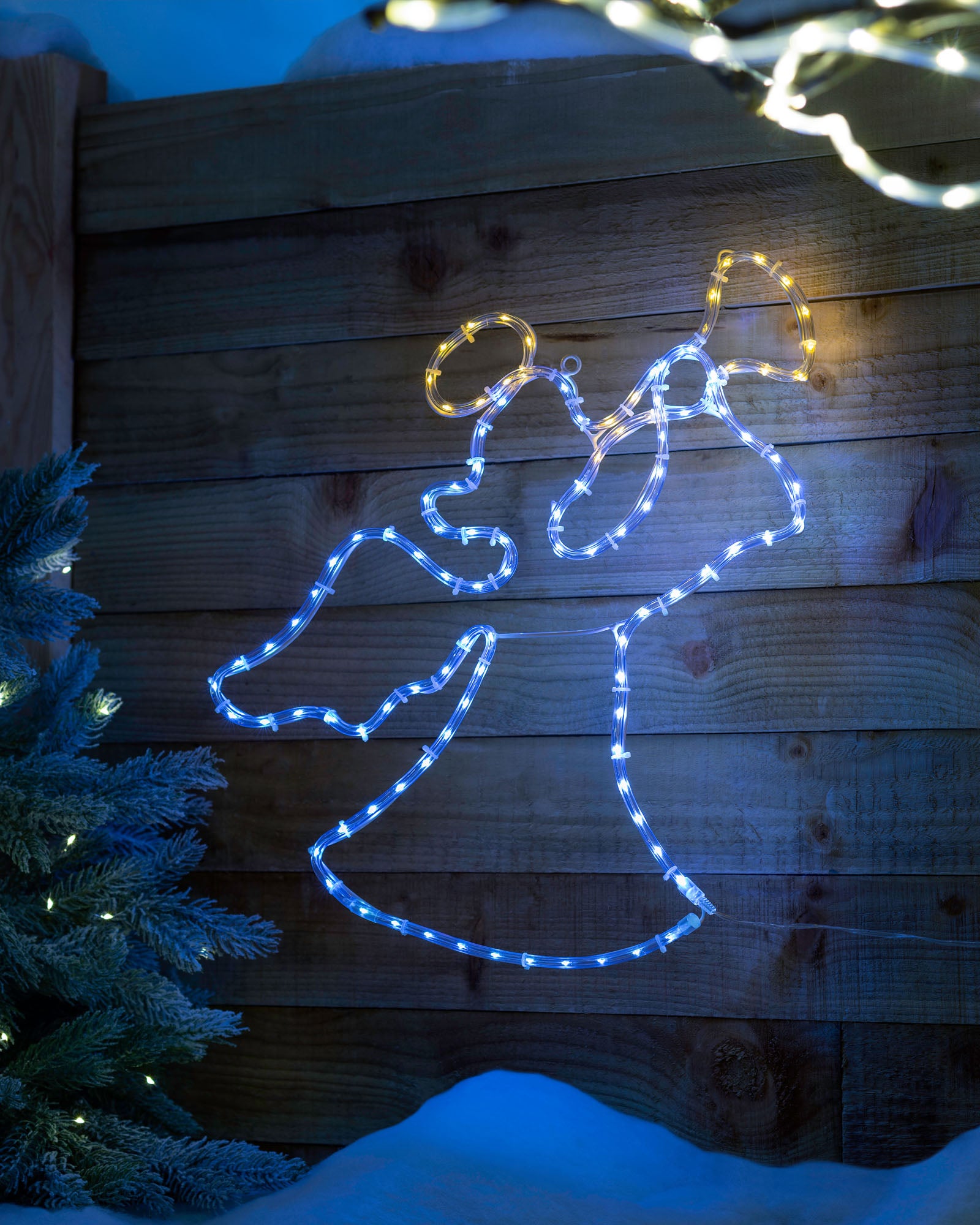 An angel silhouette created by a rope light with warm white and yellow LED lights against a wooden backdrop.