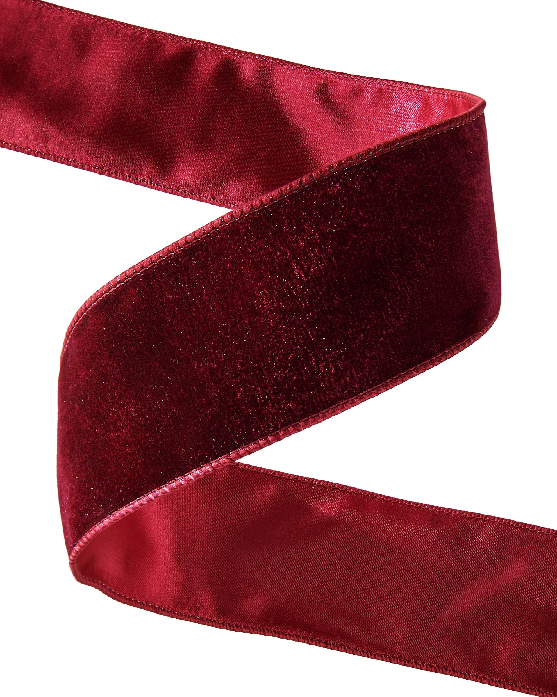 Close-up of a red velvet ribbon on a white background