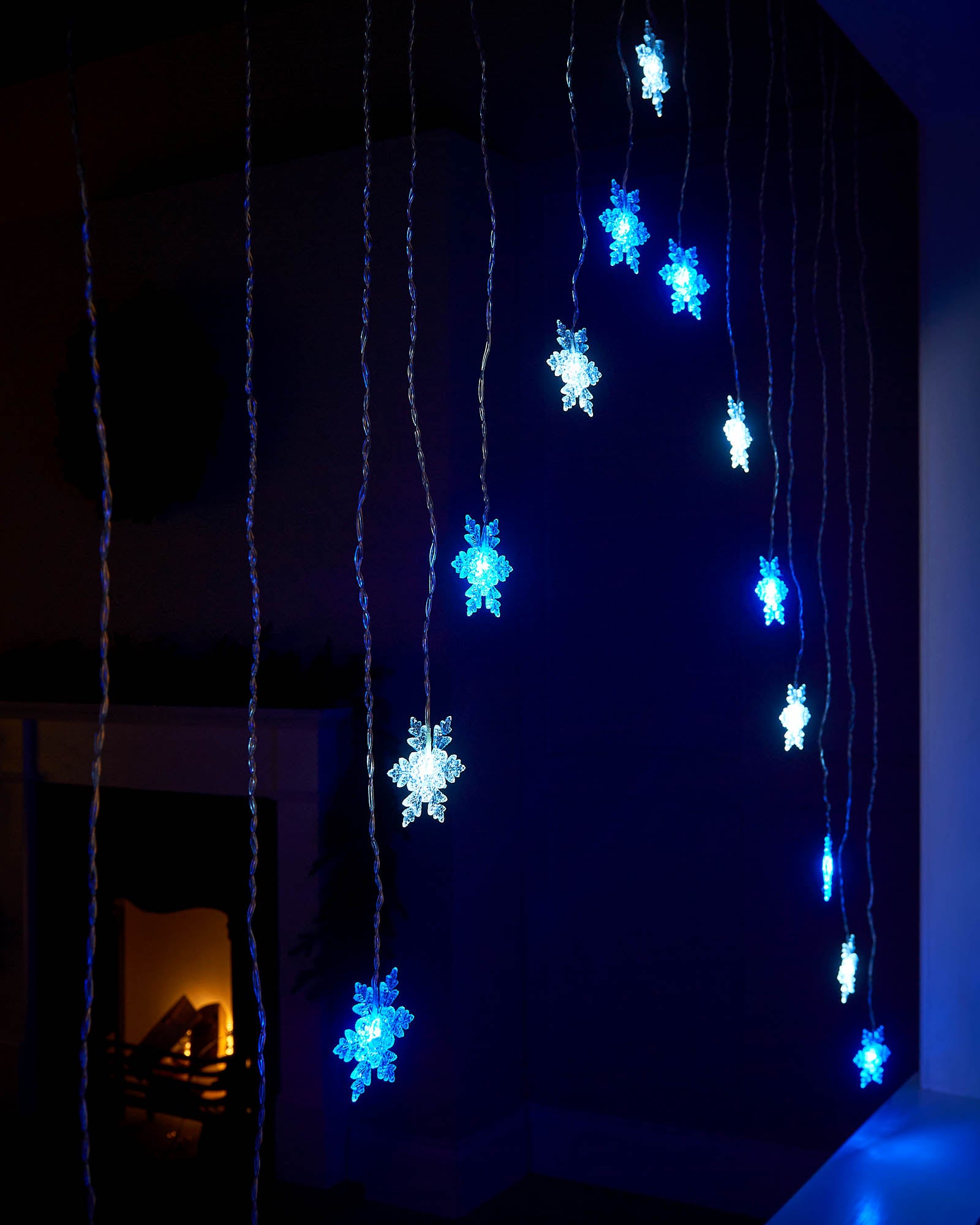 Hanging blue and white LED snowflake curtain lights shown from the side