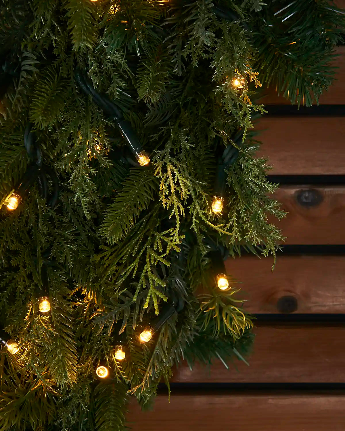 Detailed view of the natural fir wreath foliage with warm white lights.