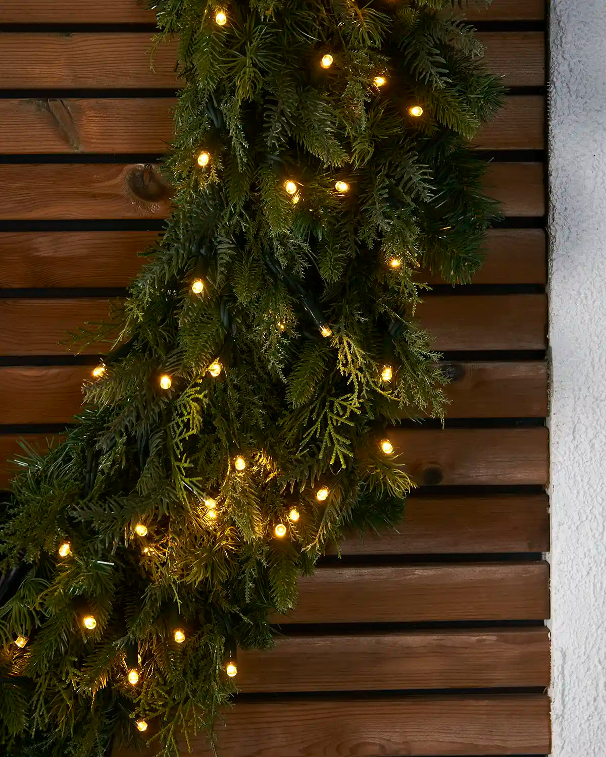 Side close-up of the pre-lit natural fir wreath with warm white LEDs.