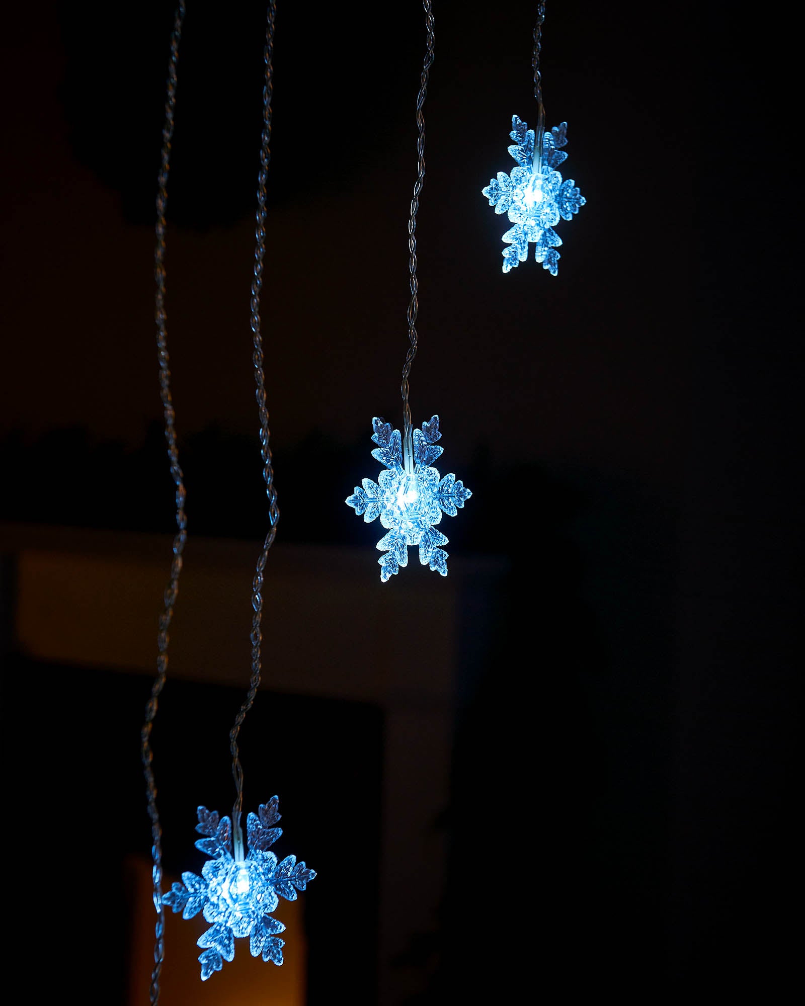 White snowflake curtain lights hanging at different heights
