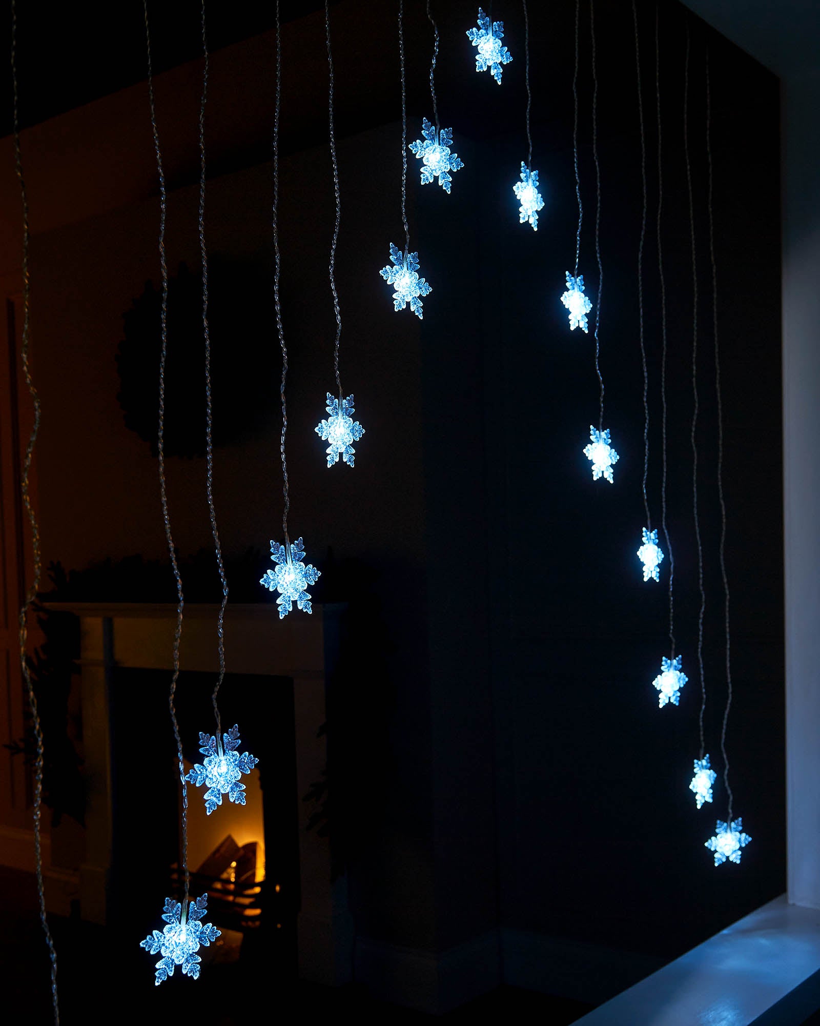 Hanging white LED snowflake curtain lights shown from the side