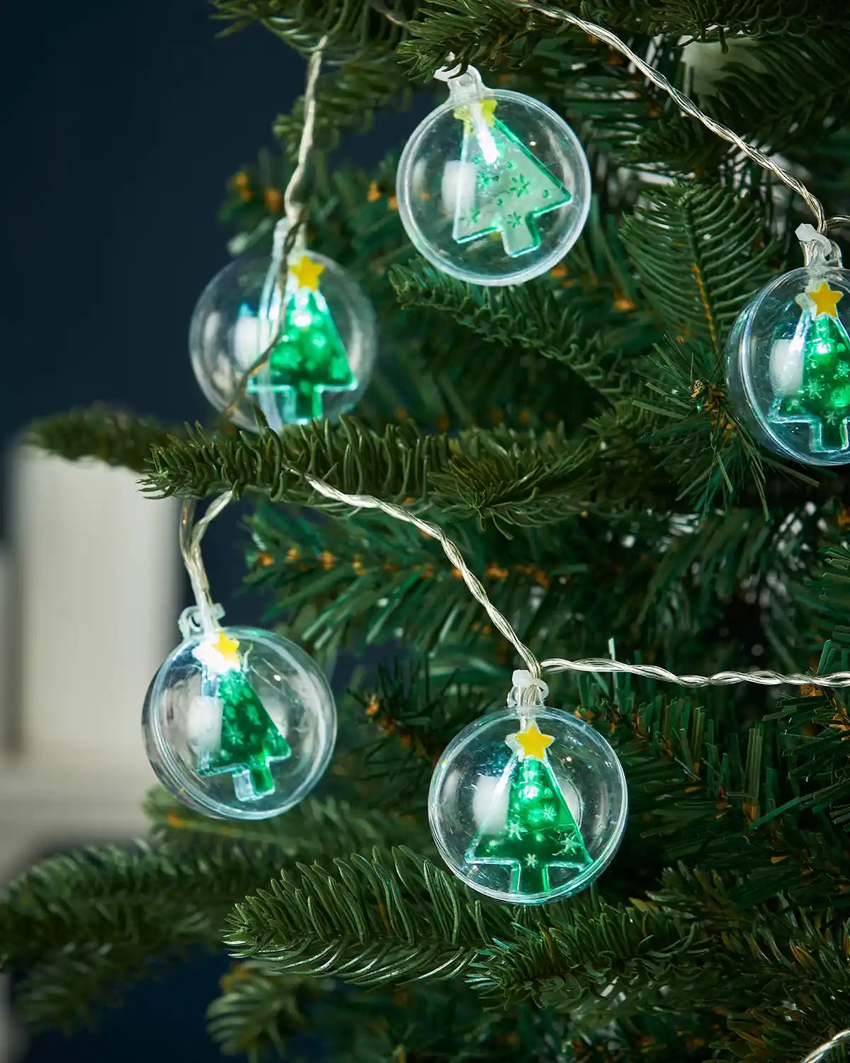 Christmas tree bauble LED string lights hanging on a Christmas tree
