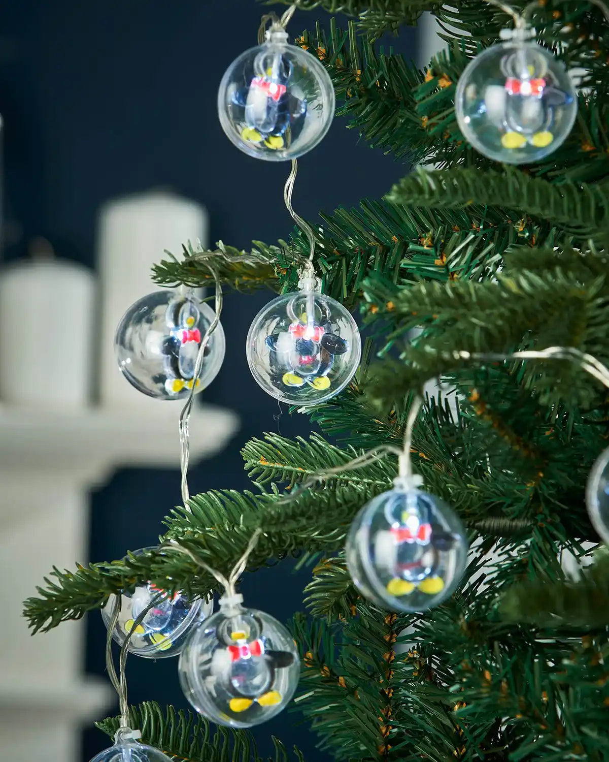 Penguin bauble LED string lights hanging on a Christmas tree