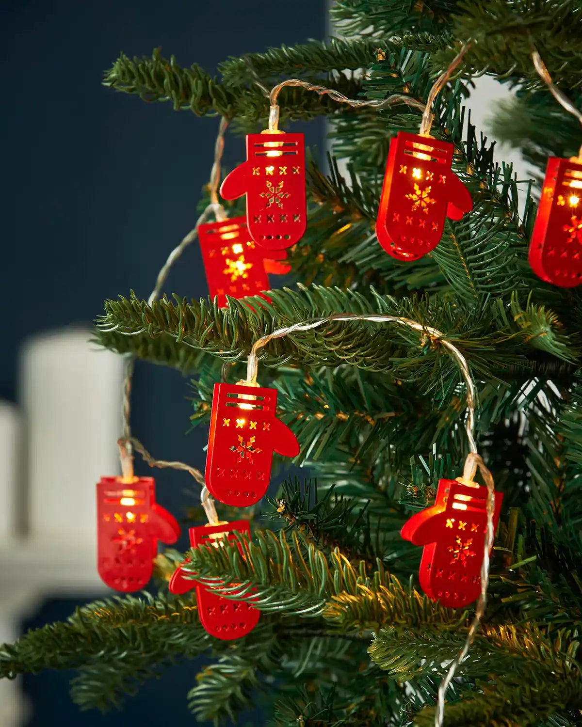Santa gloves LED string lights hanging on a Christmas tree