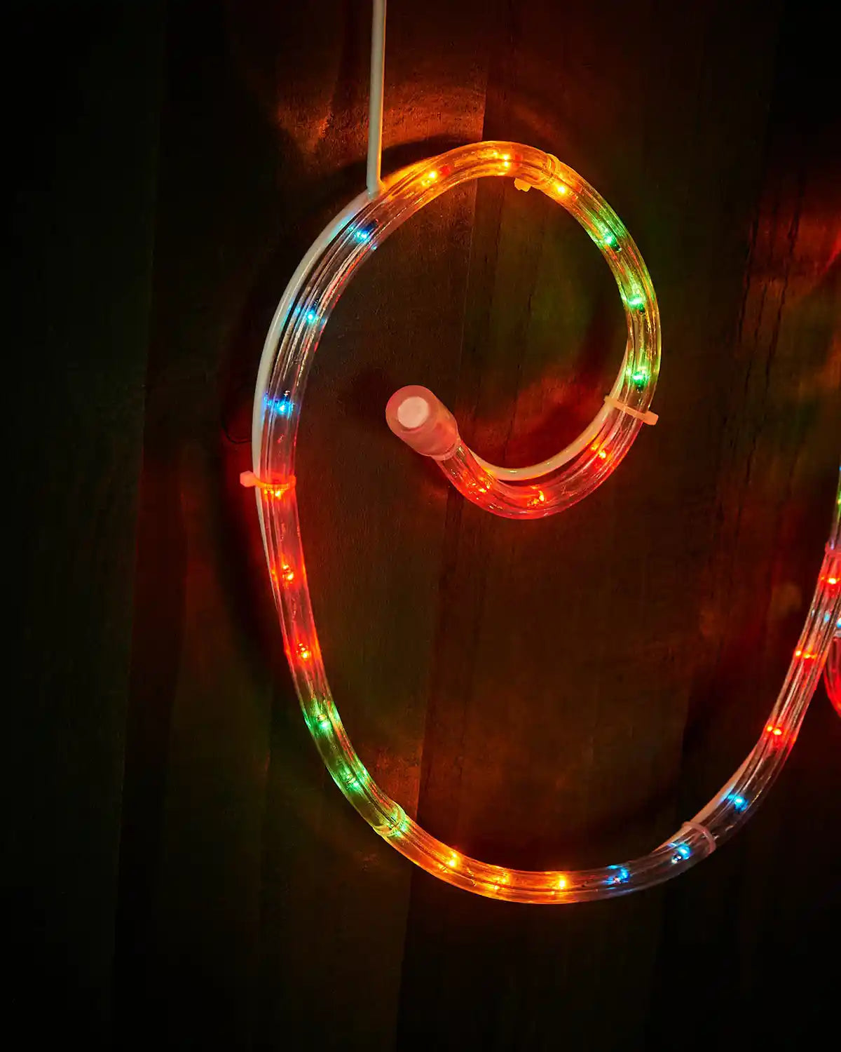 Close-up of curved multi-coloured LED rope light on the Merry Christmas display