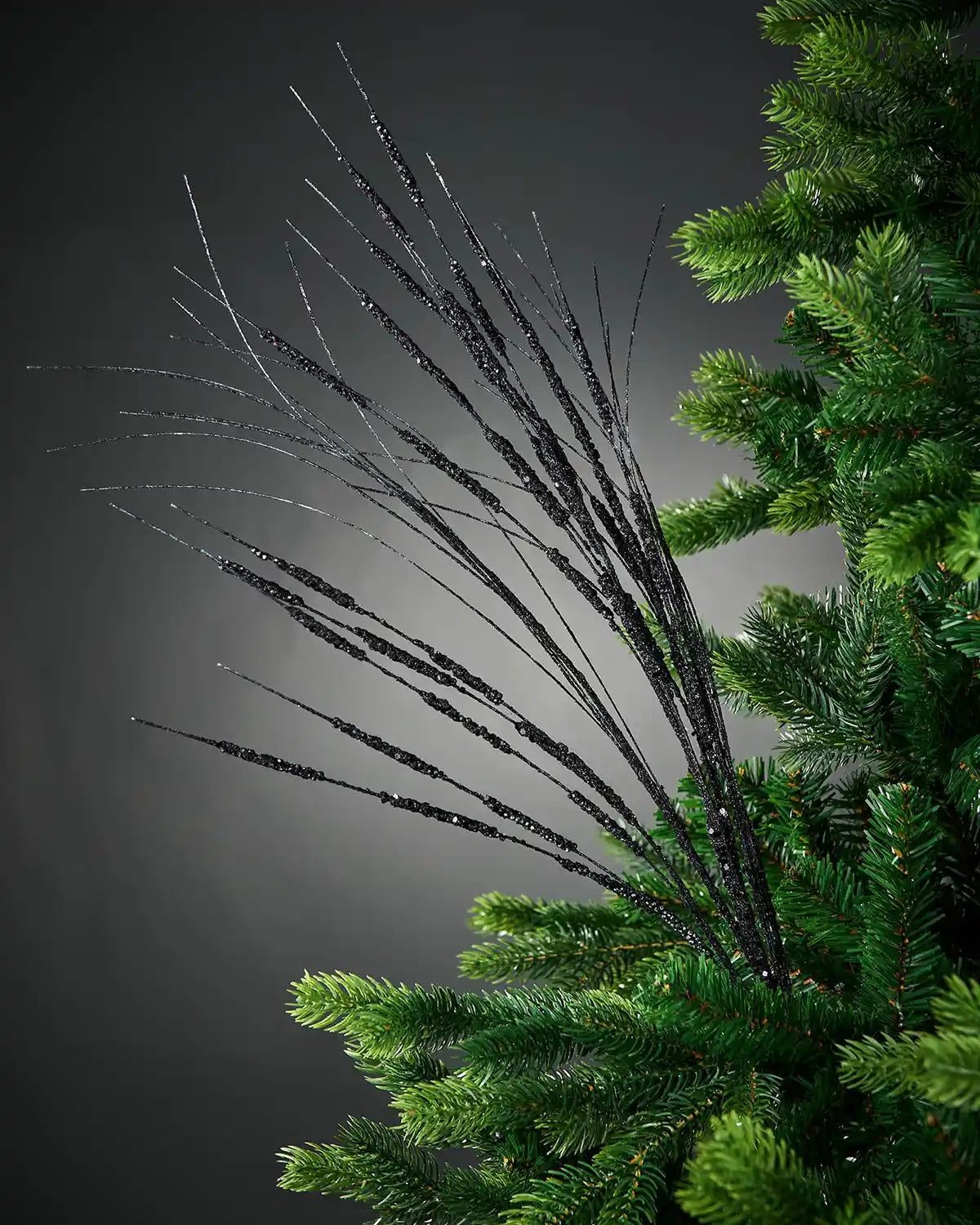 100cm black glitter wispy tree spray attached to tree in front of grey background