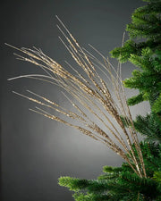 100cm gold glitter wispy spray attached to Christmas tree in front of grey background 
