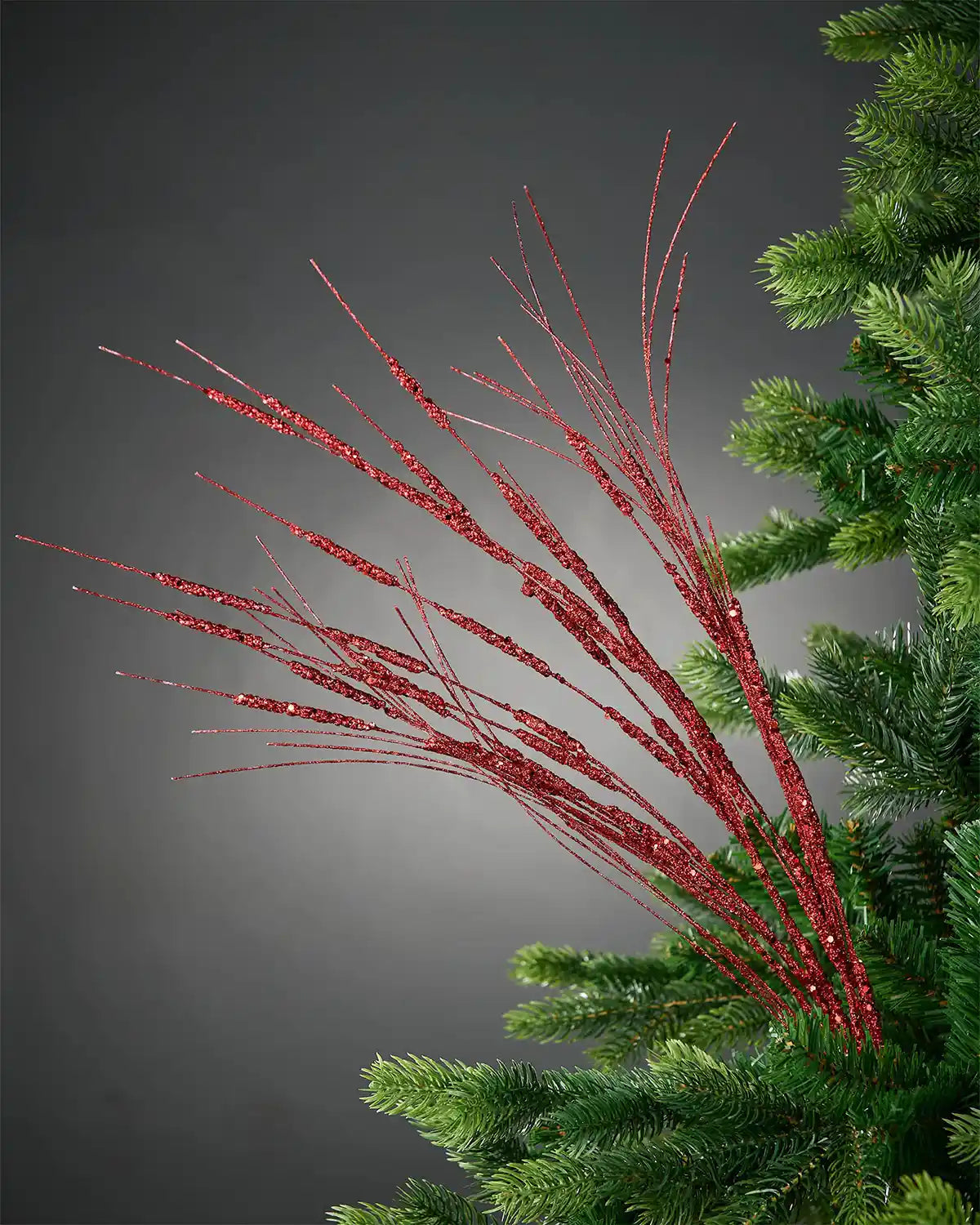 Image of 100cm red glitter wispy spray in Christmas tree in front of grey background