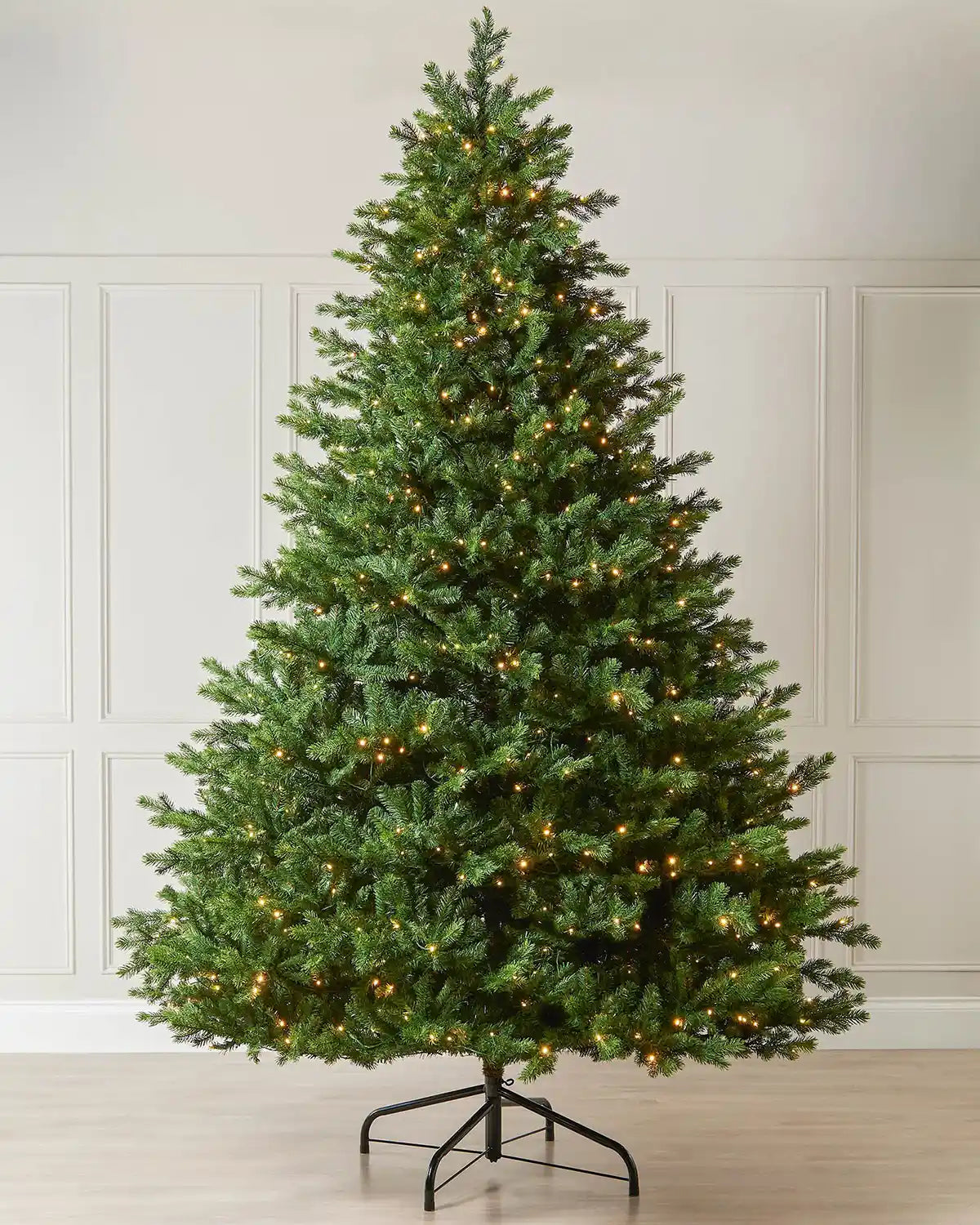 Full view of the 10ft pre-lit balsam fir Christmas tree with warm white LED lights on a metal tree stand.