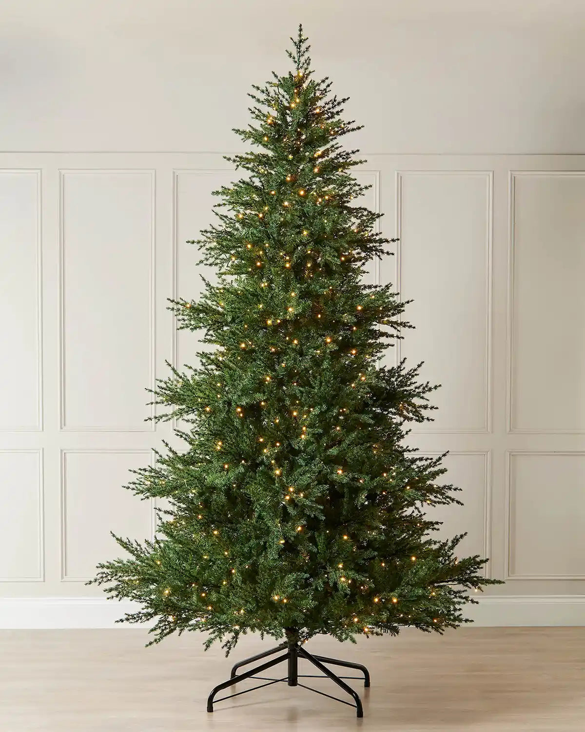10ft pre-lit Traditional Fir Christmas tree with warm white LEDs displayed indoors on a metal tree stand.