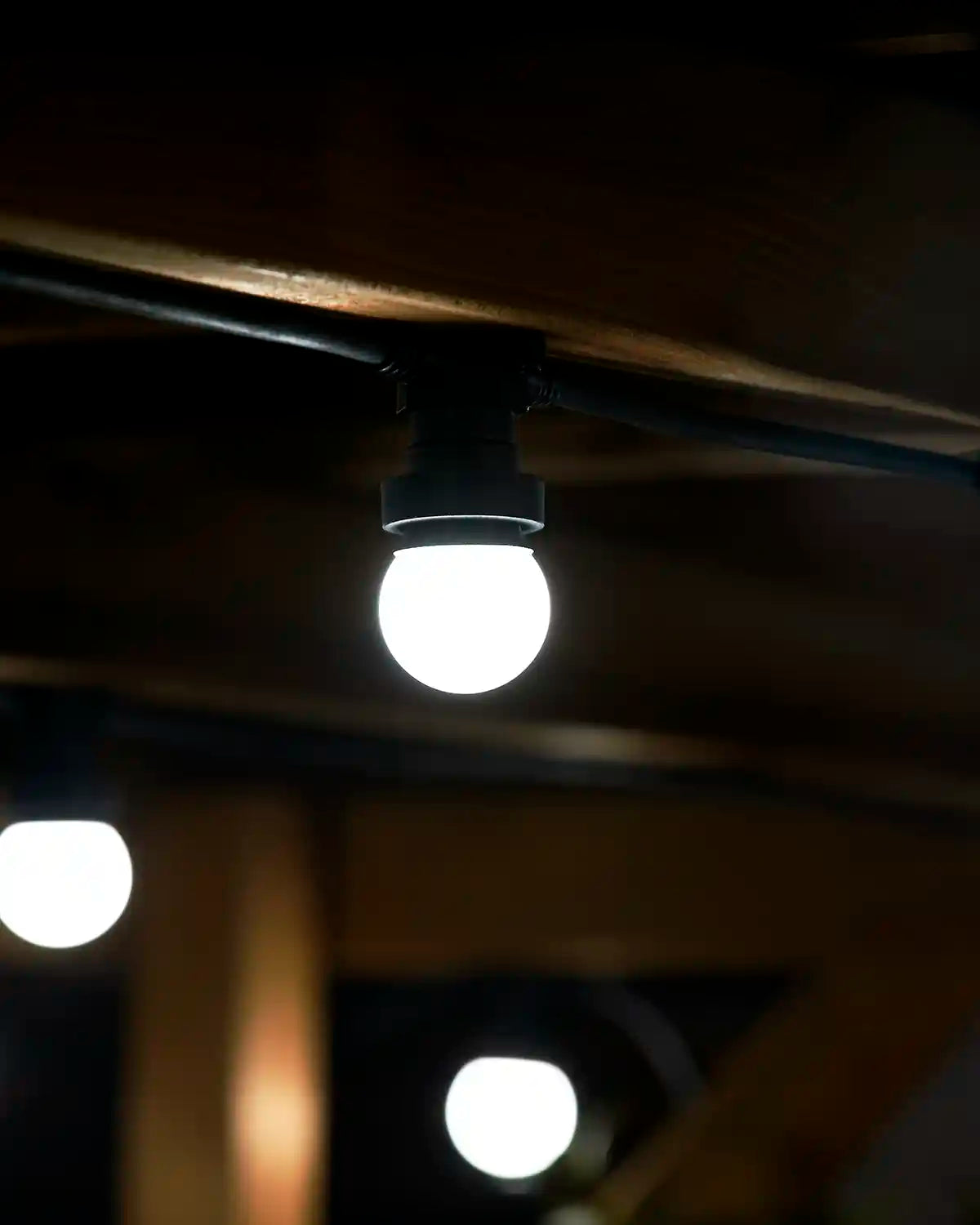 Close-up of a white festoon bulb with softly blurred bulbs in the background.