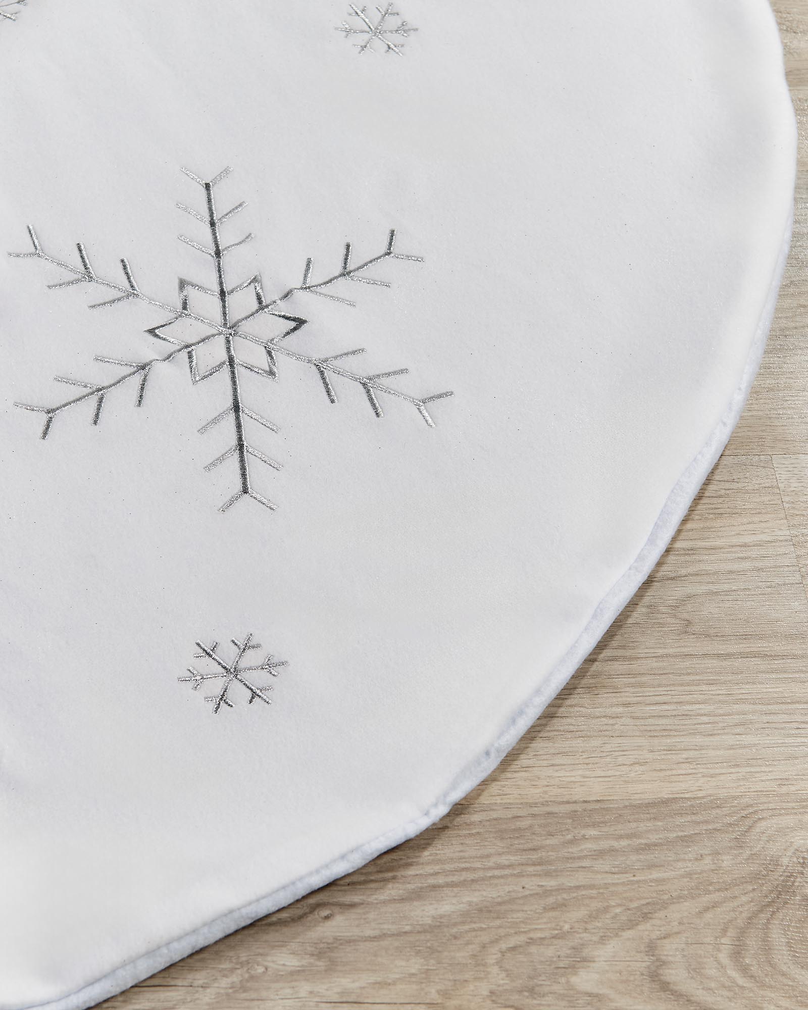 Close-up of the 122 cm tree skirt showing silver snowflake detail and soft edging