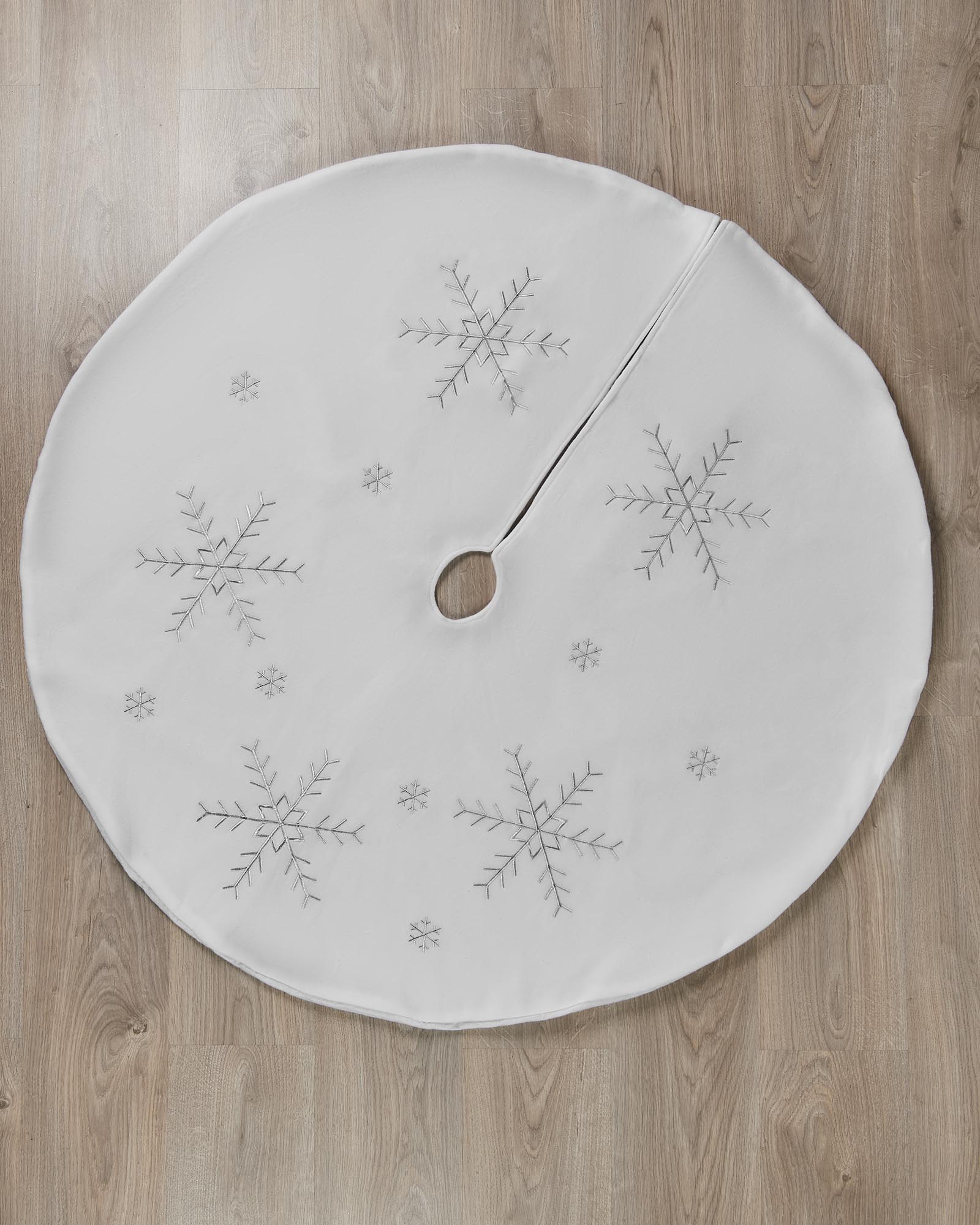 Top view of a 122 cm white Christmas tree skirt with silver snowflake embroidery and centre opening