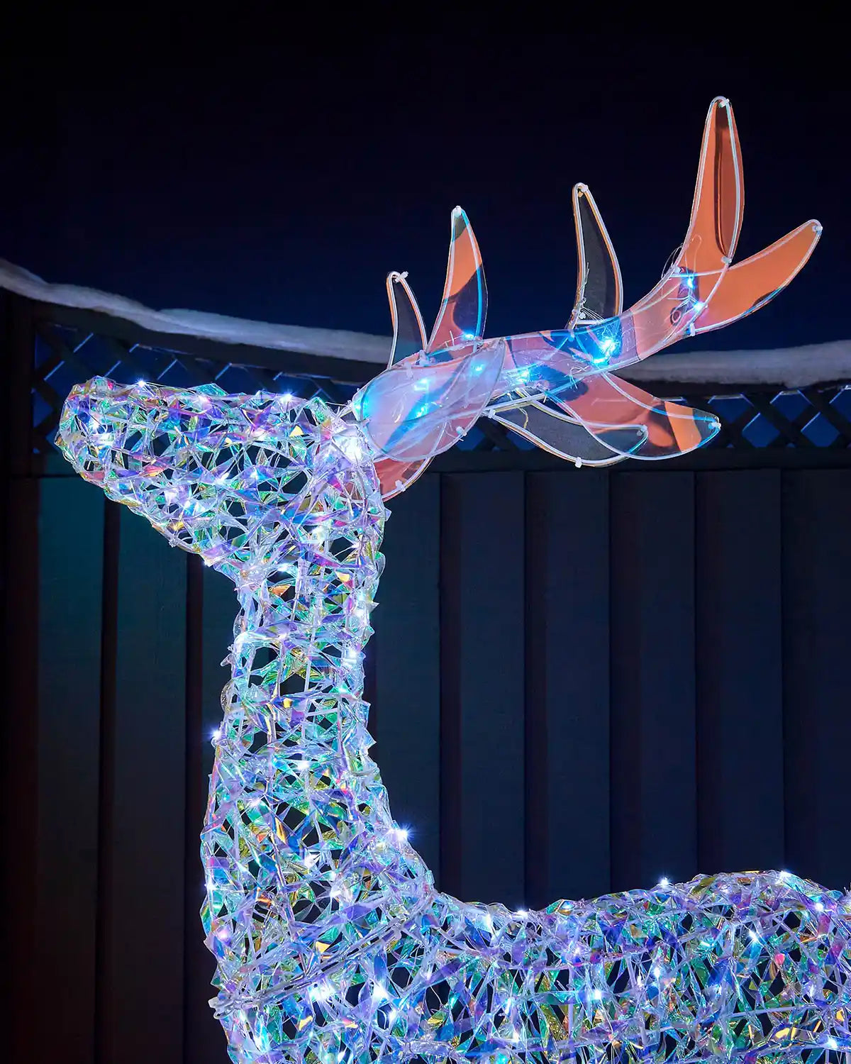 Close-up of the tall iridescent reindeer showing the head, antlers and cool white LED lights.