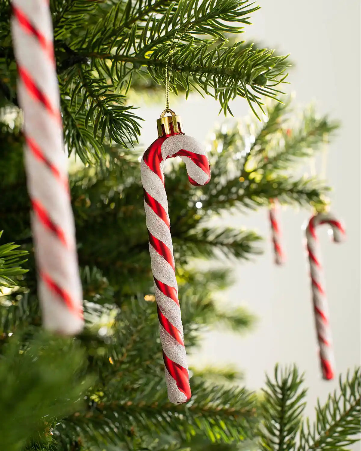13cm red and white candy cane baubles hanging on a Christmas tree
