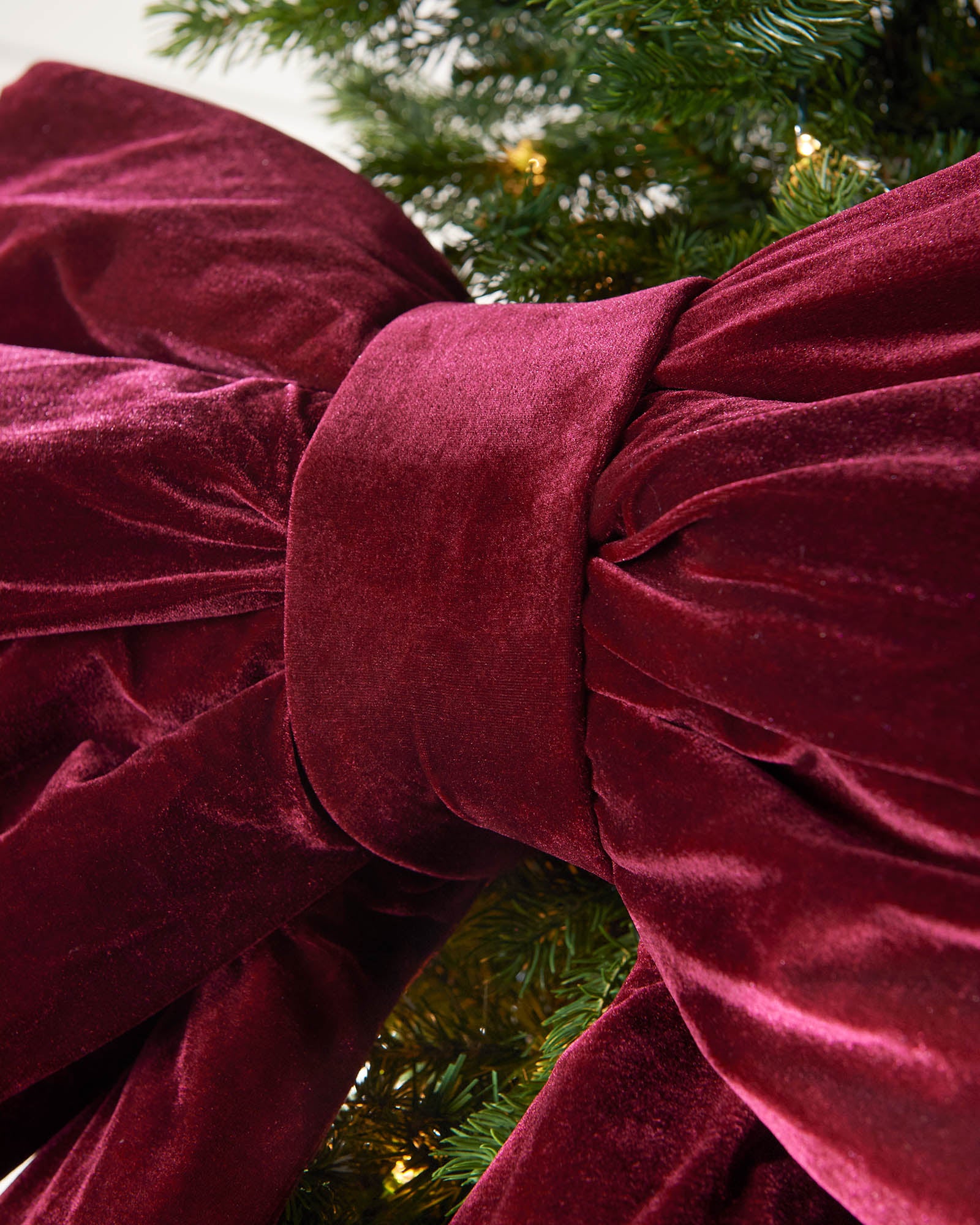 Detail close-up of the centre of a large burgundy velvet Christmas bow