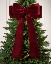 Large 140cm burgundy velvet Christmas bow displayed on a lit Christmas tree