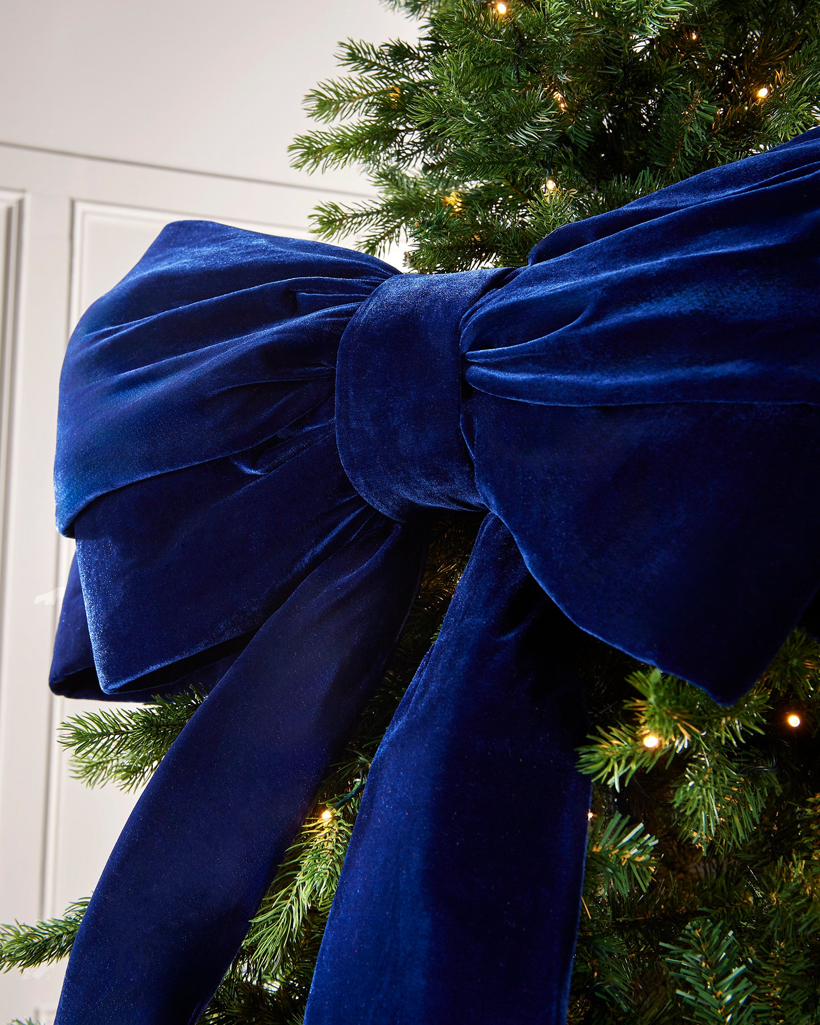 Close-up of a large navy velvet Christmas bow on a Christmas tree