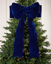 Large 140cm navy velvet Christmas bow displayed on a lit Christmas tree