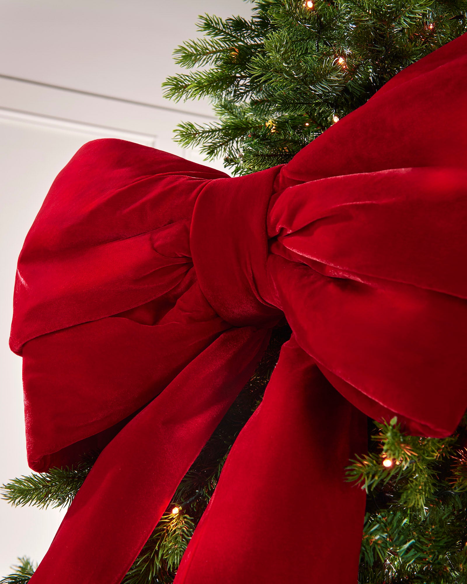 Close-up of a large red velvet Christmas bow on a Christmas tree