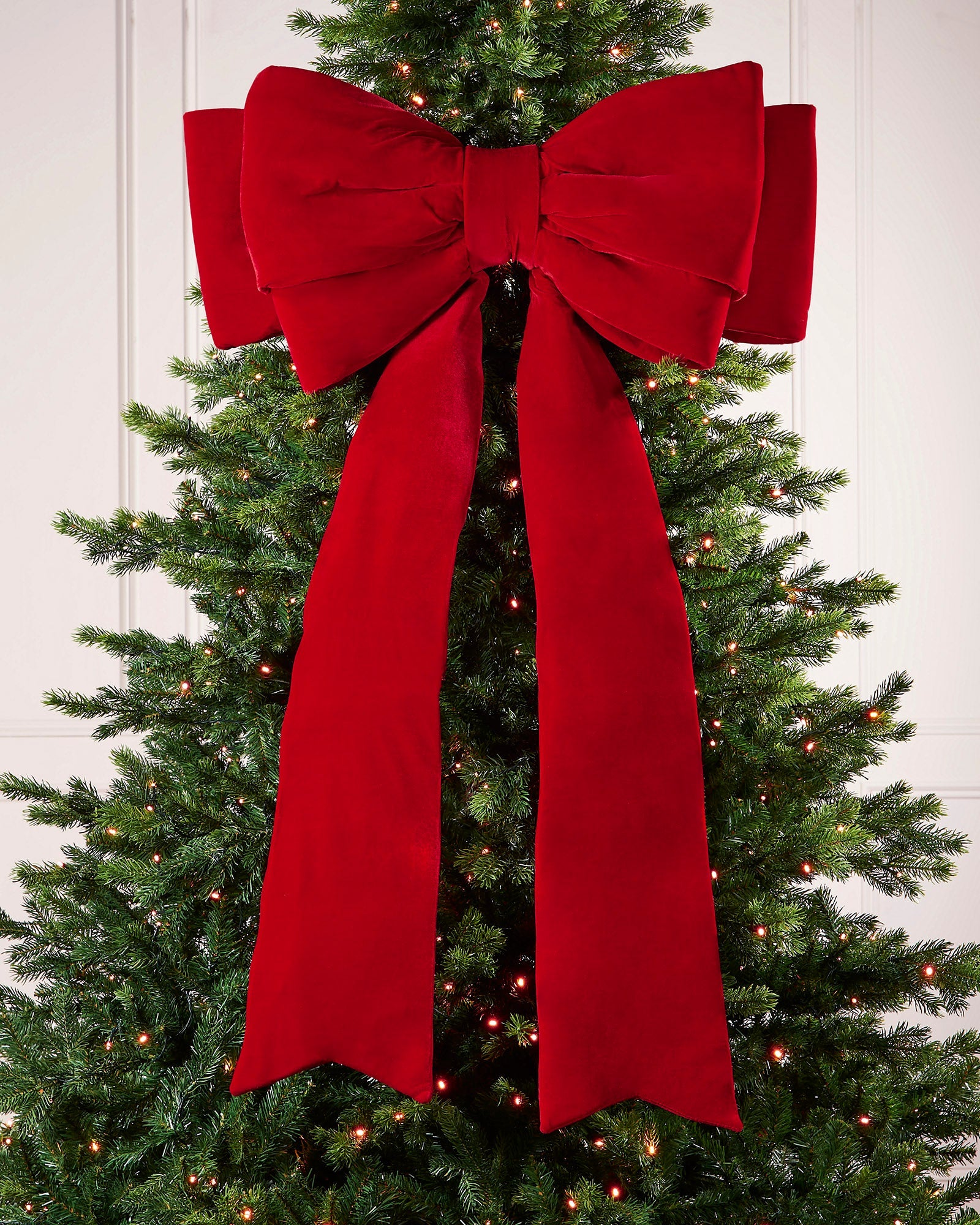 Large 140cm red velvet Christmas bow displayed on a lit Christmas tree